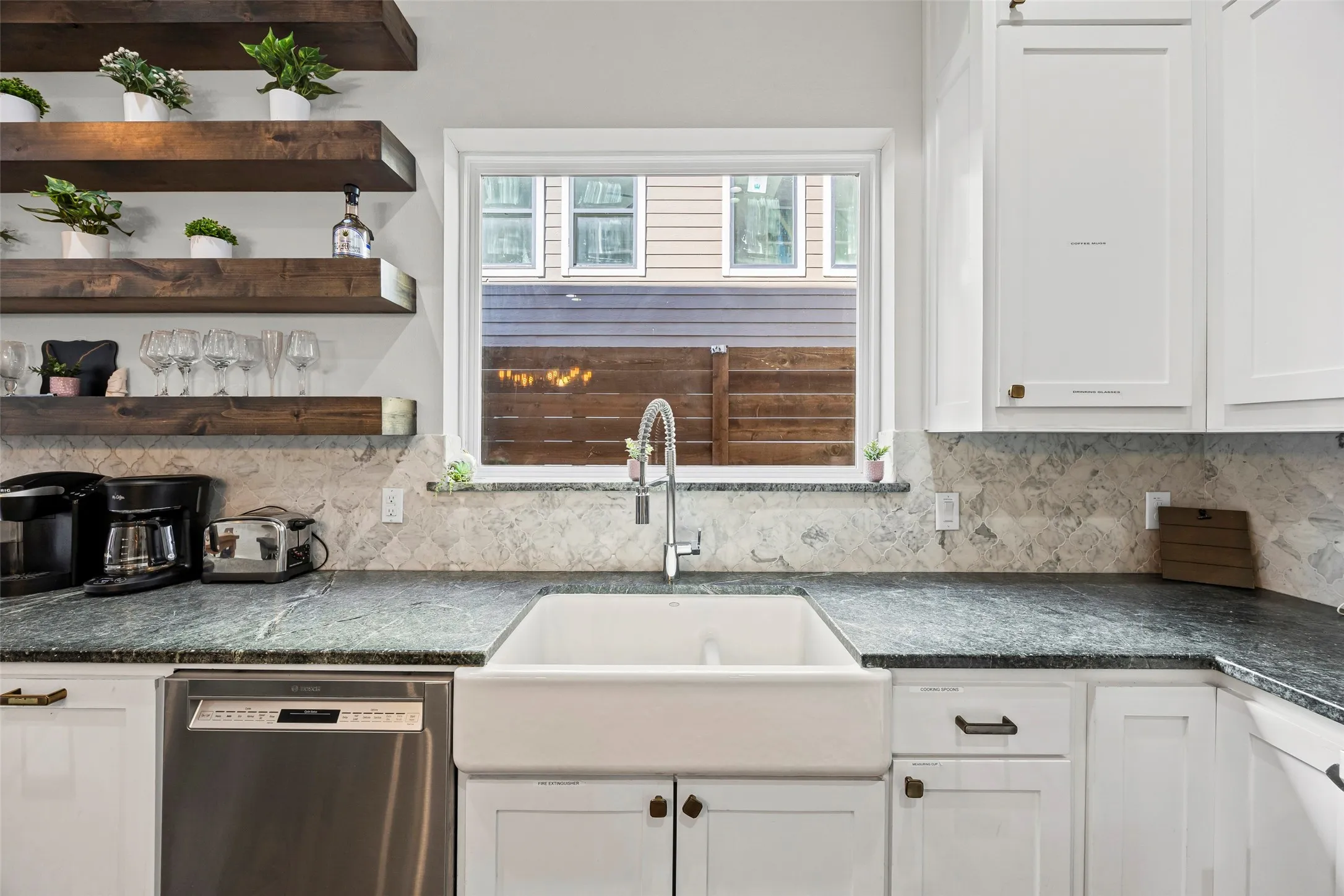 The updated kitchen has granite counters, stainless appliances, gas stove, lots of cabinets, plus open shelving