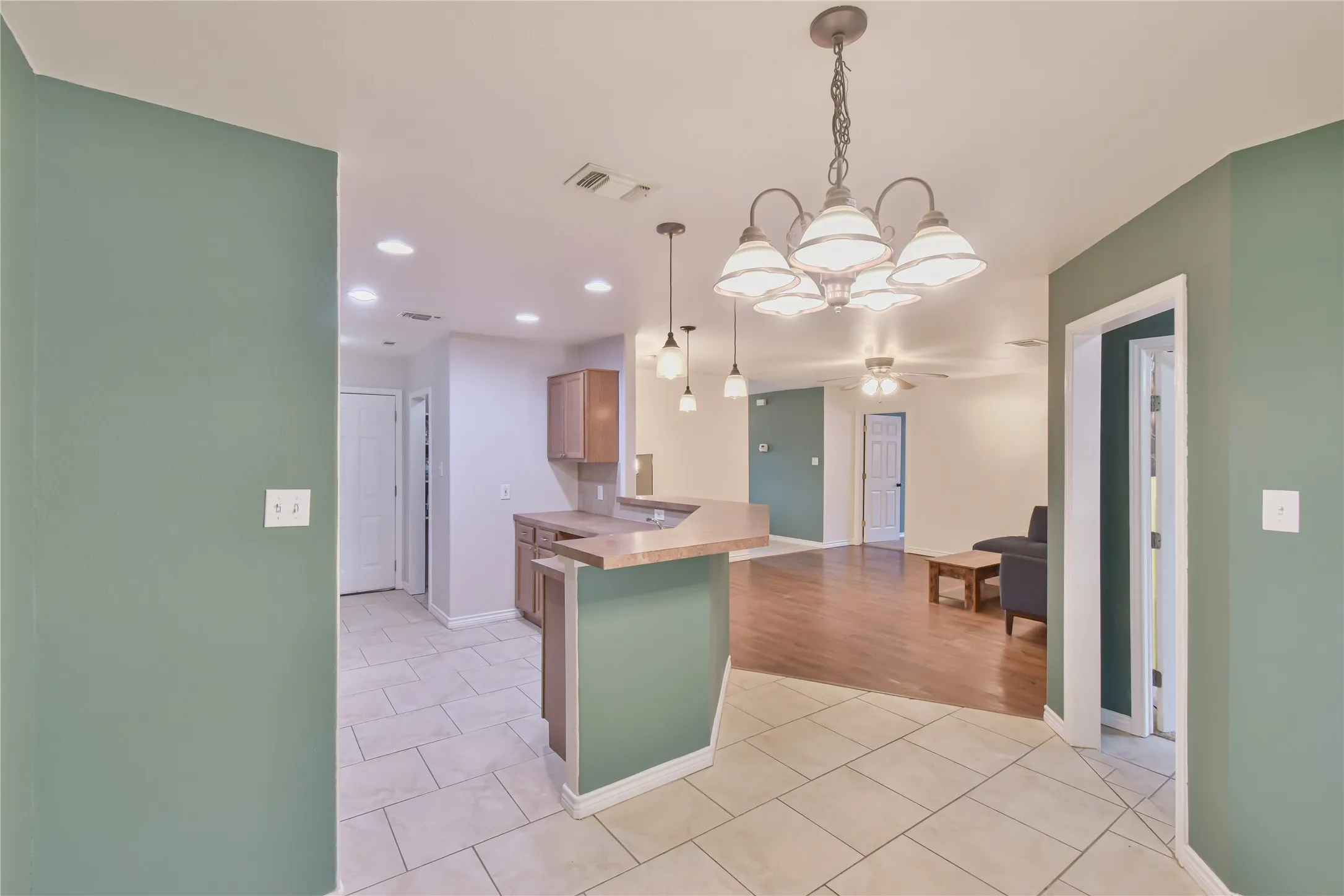 Open concept living space featuring a breakfast bar, recessed lighting, and a multi-light chandelier