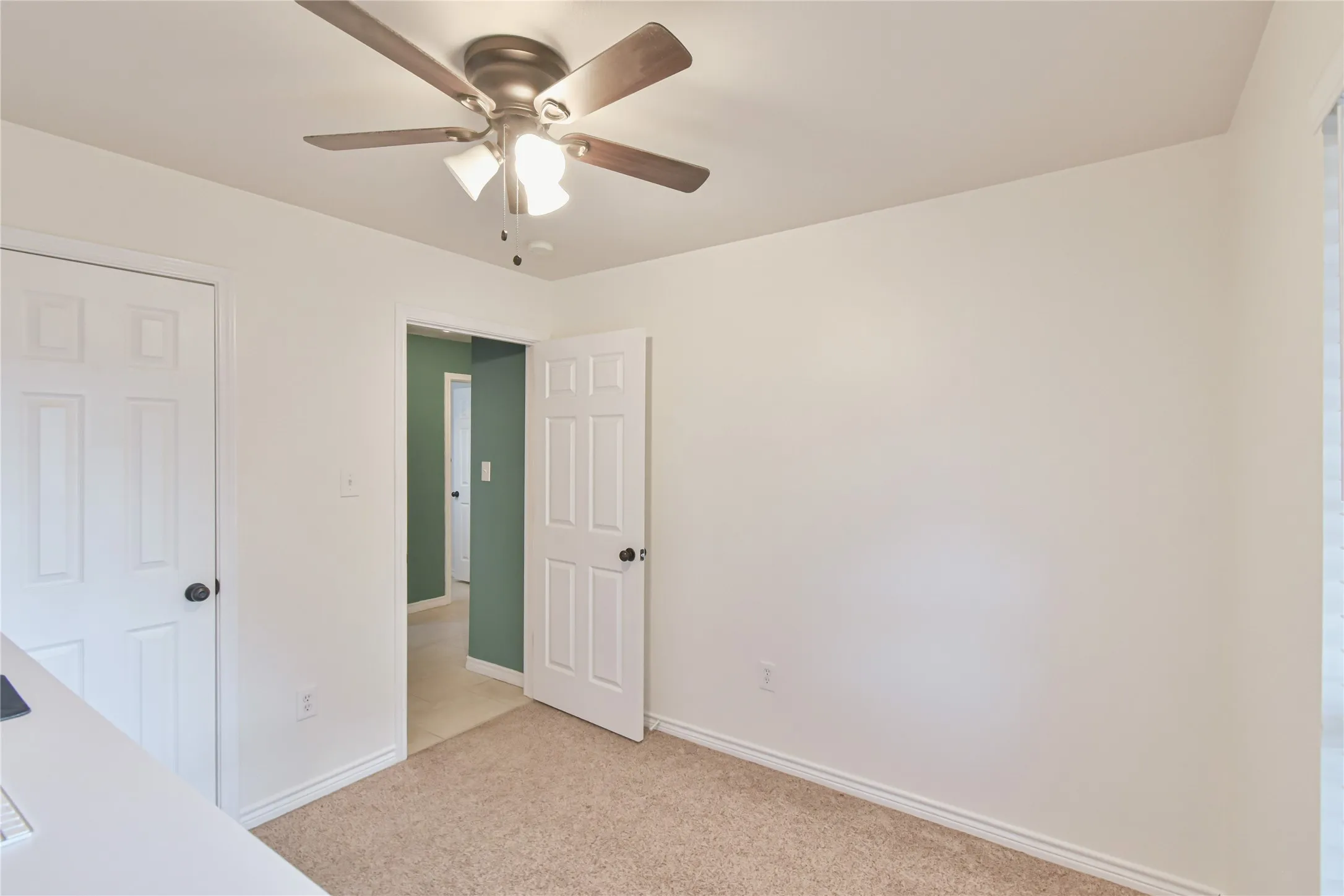 Recessed panel doors, ceiling fan with integrated lighting, and neutral carpeting