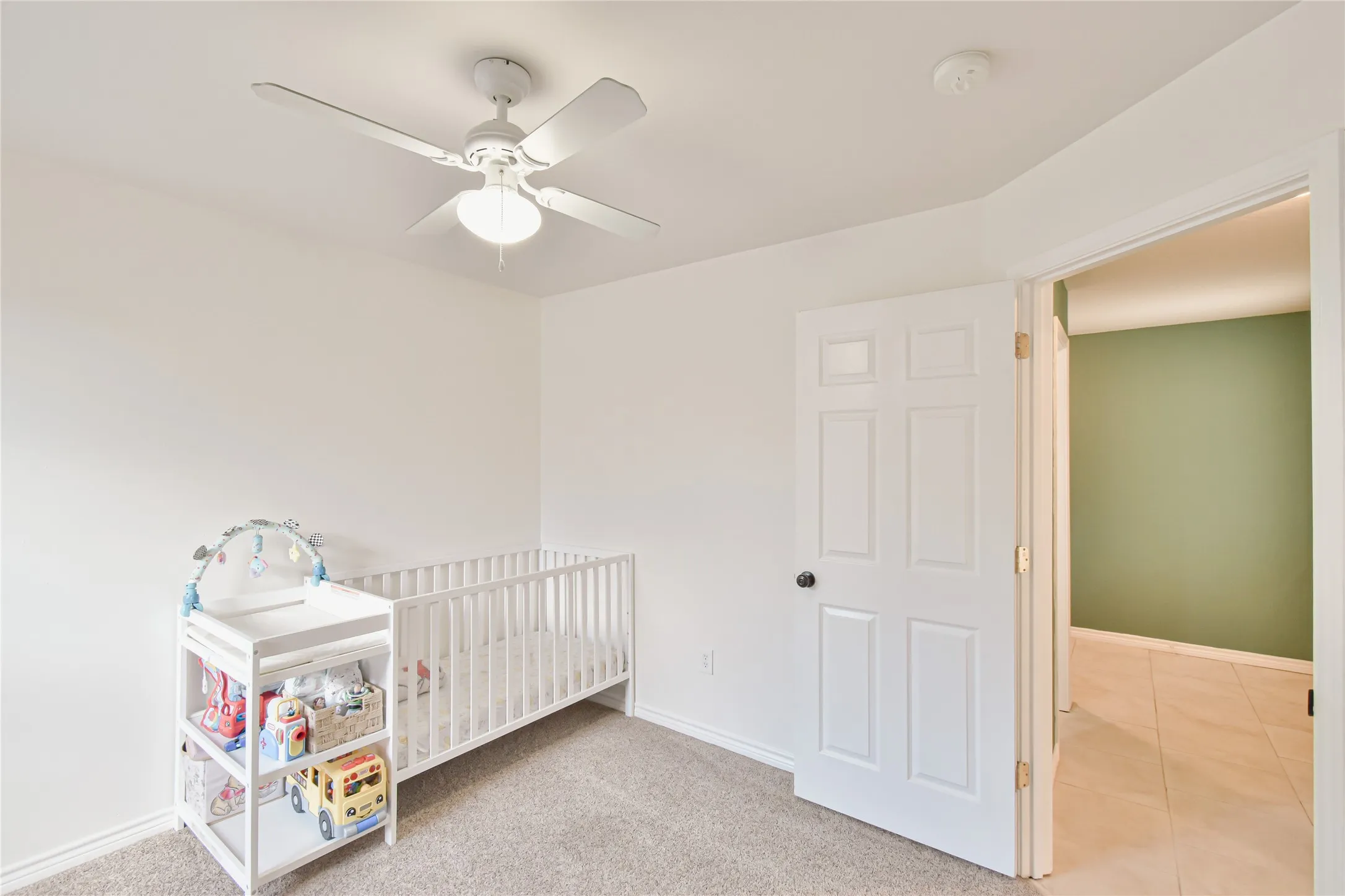 Recessed ceiling fan with integrated lighting, carpeted flooring, white trim, and a white six-panel door