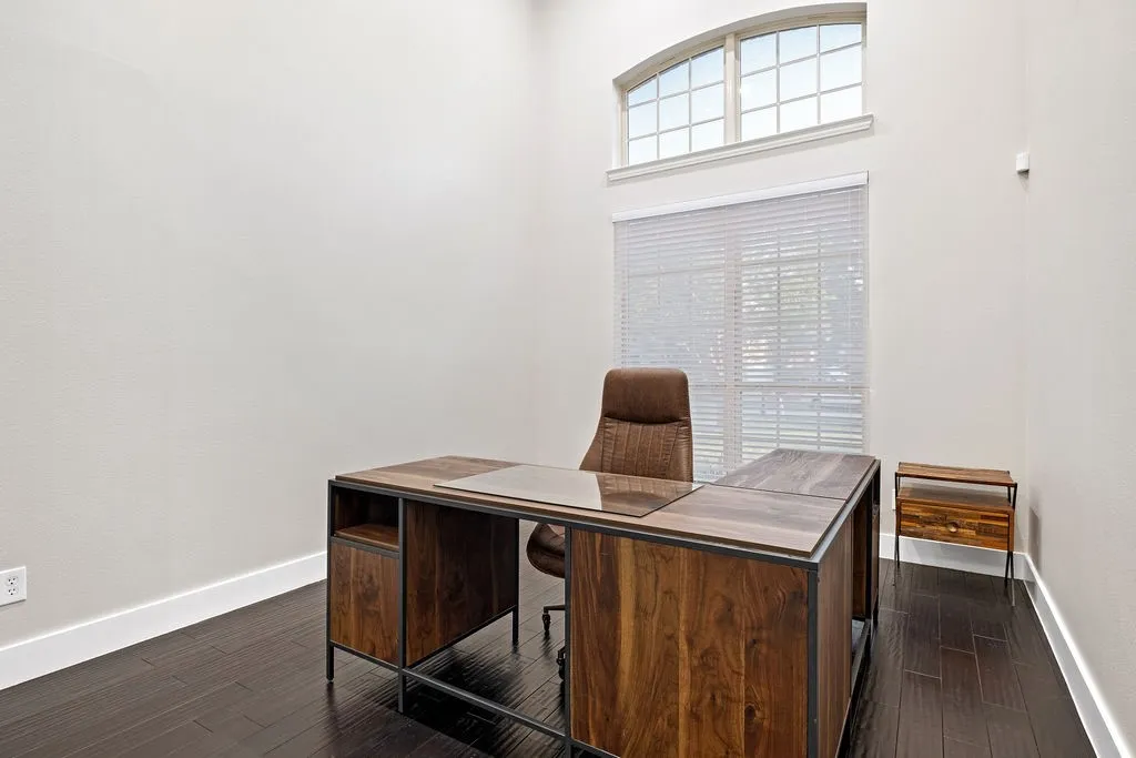 High ceilings, wood-finish flooring, and a large window with blinds