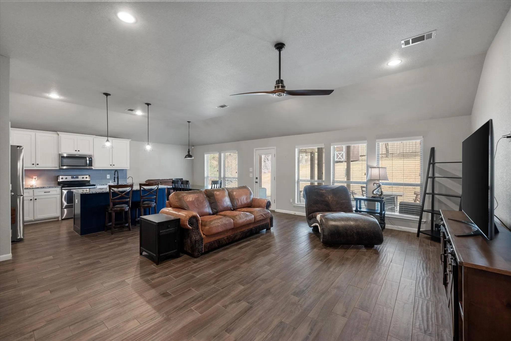 Open concept living with a wall of windows facing the back yard