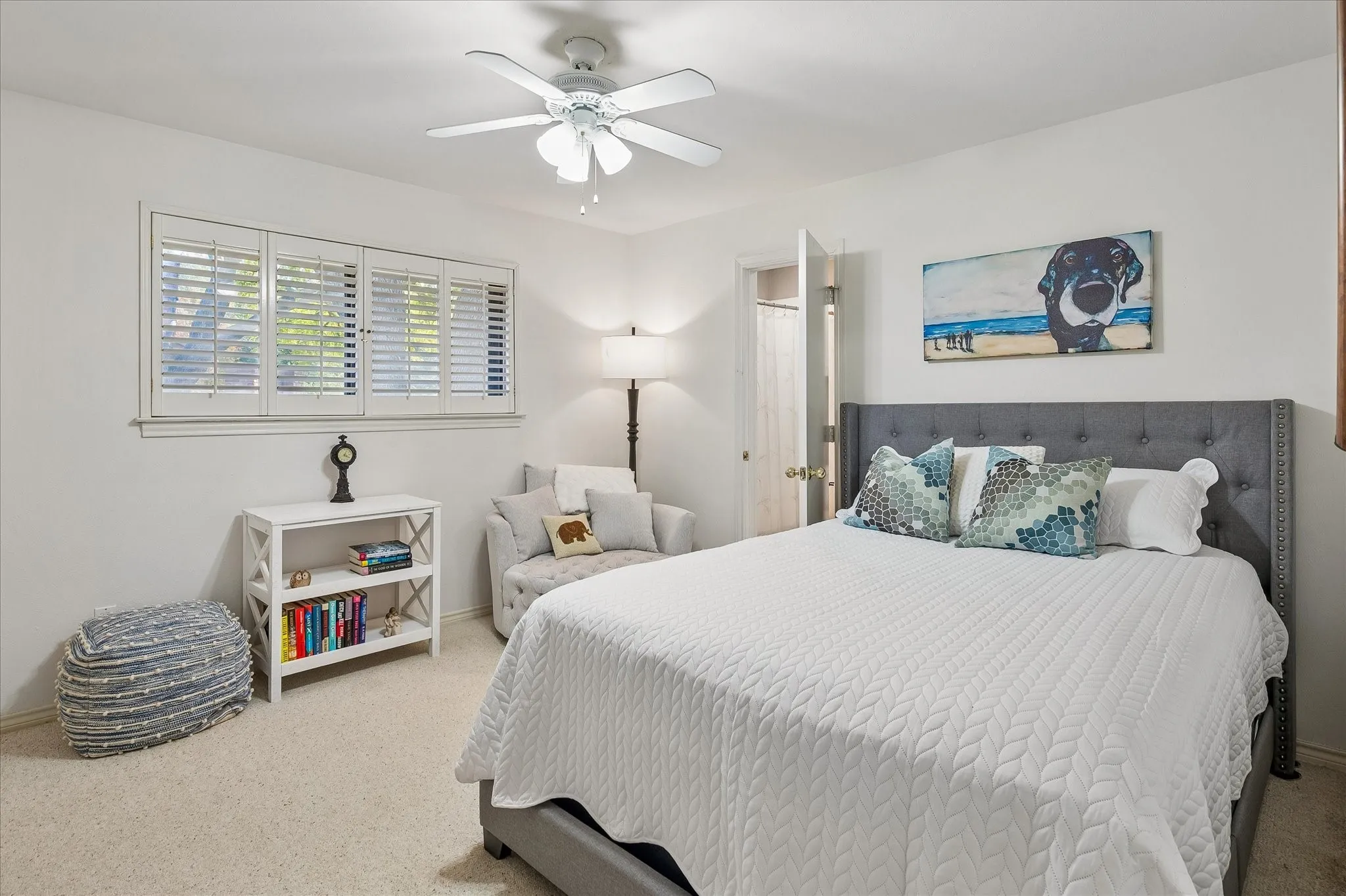 Neutral tone wall finishes, white plantation shutters, and a ceiling fan with integrated lighting