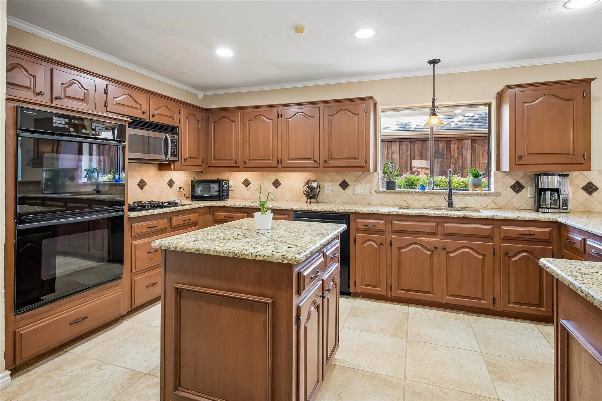 Kitchen featuring wood cabinetry, granite countertops, tile flooring, a built-in double oven, and a central island