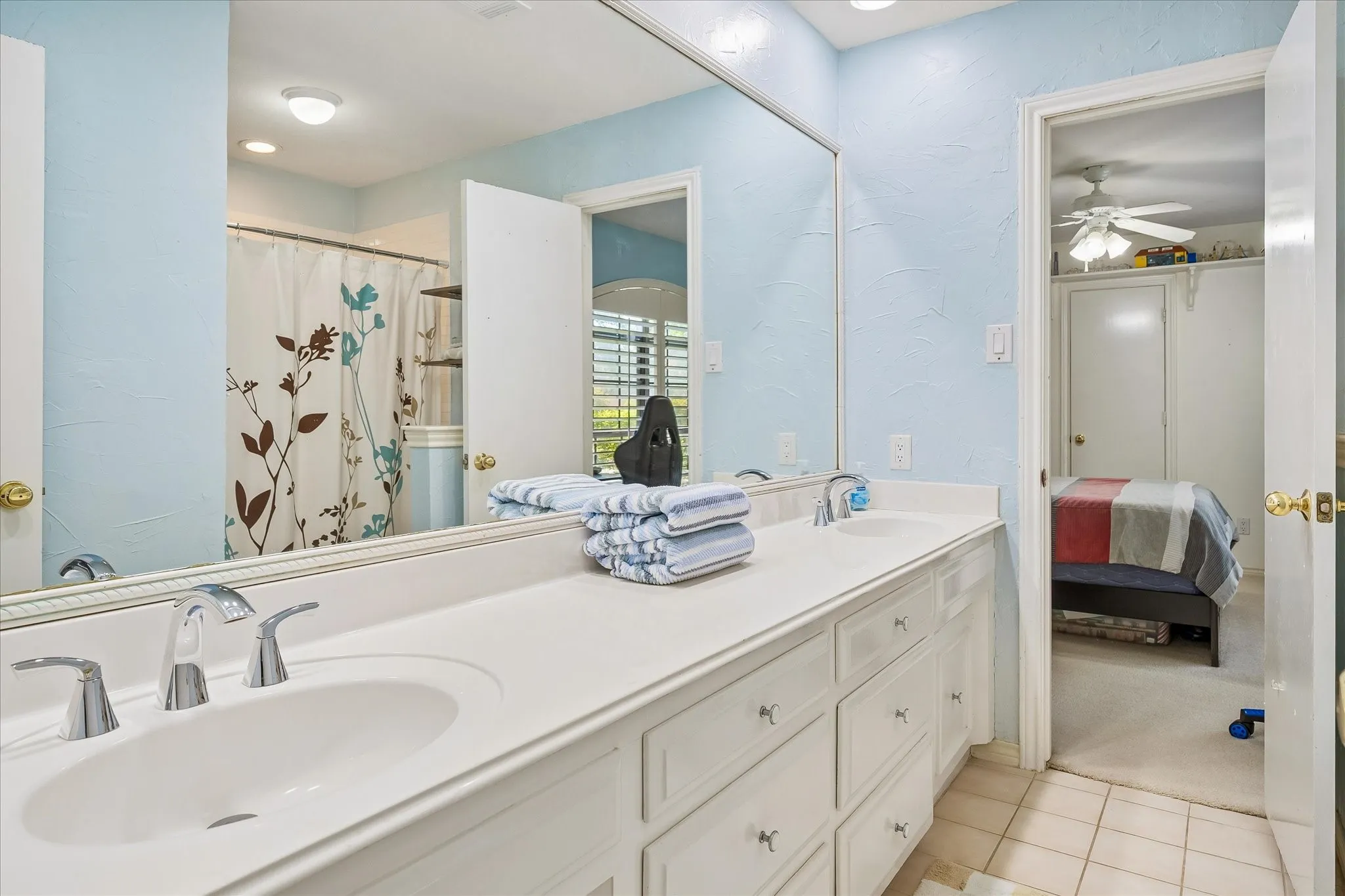 Dual under-mount sinks with chrome faucets, expansive countertop, and built-in vanity cabinetry