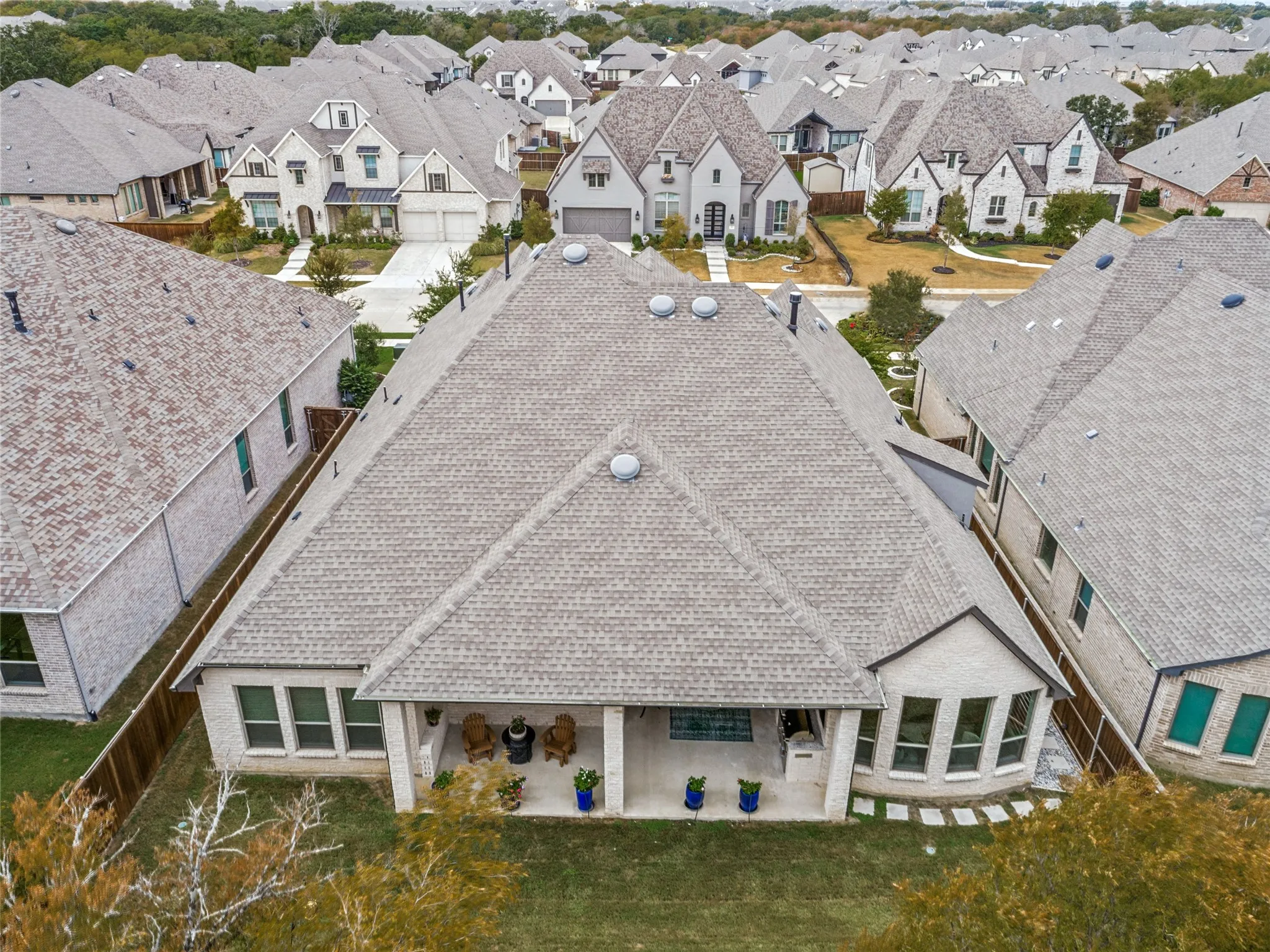 Birdseye view of the home from the back showing the expansive covered patio and abundance of windows