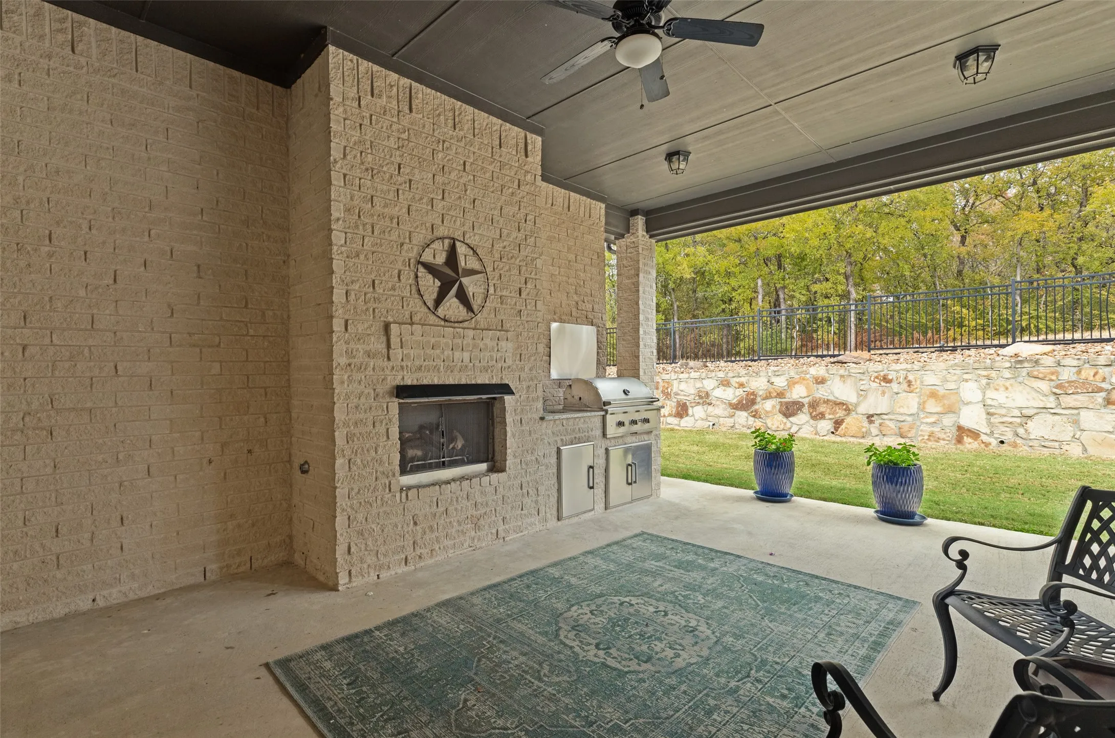 Beautiful outdoor patio with gas fireplace and built in grille with large cozy seating area while enjoying the view of the beautiful greenspace