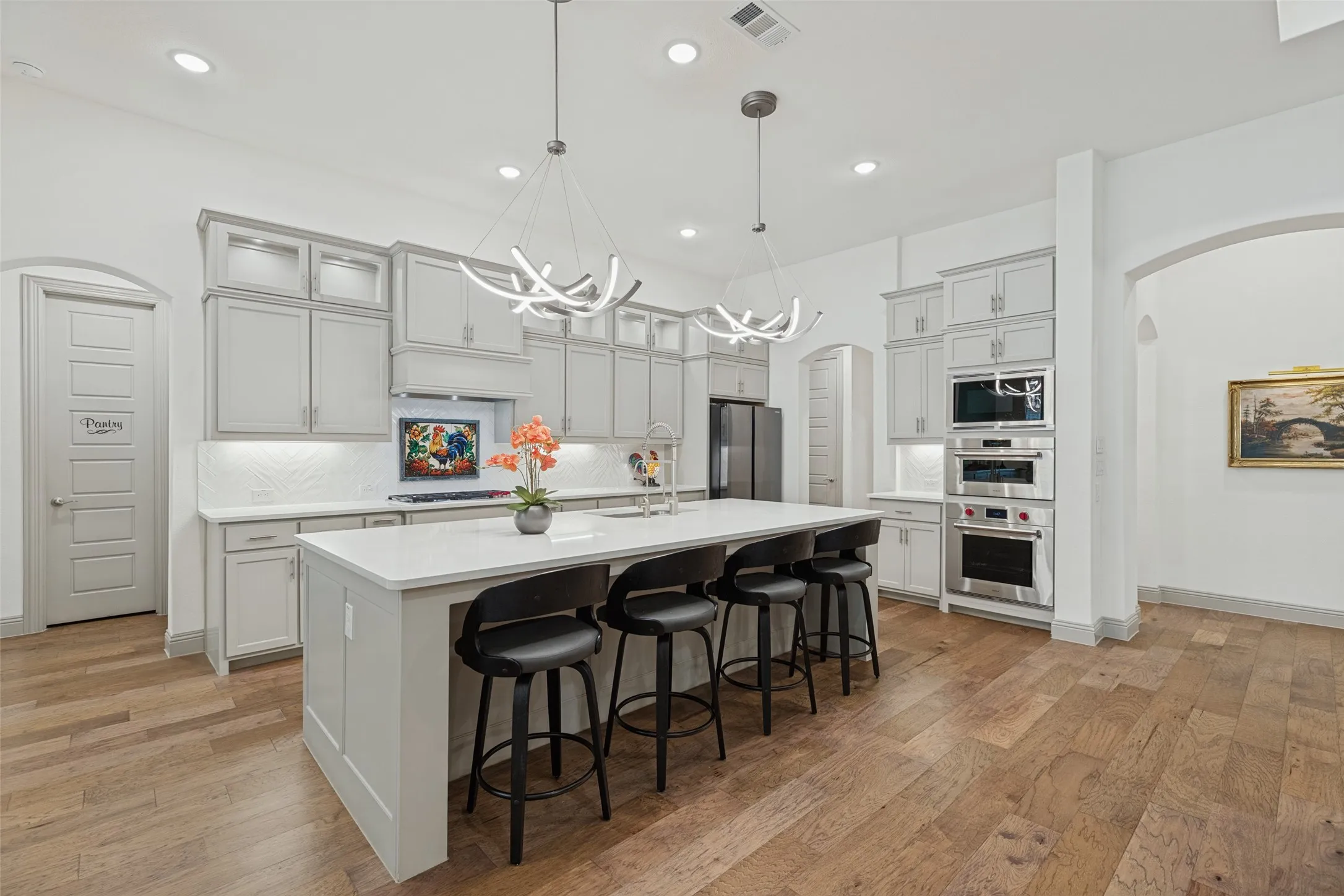 Eat in kitchen with quartz countertops, Wolf cooktop, double ovens and microwave, an abundance of storage, undercabinet lighting, top cabinet lighting and a large walk in pantry