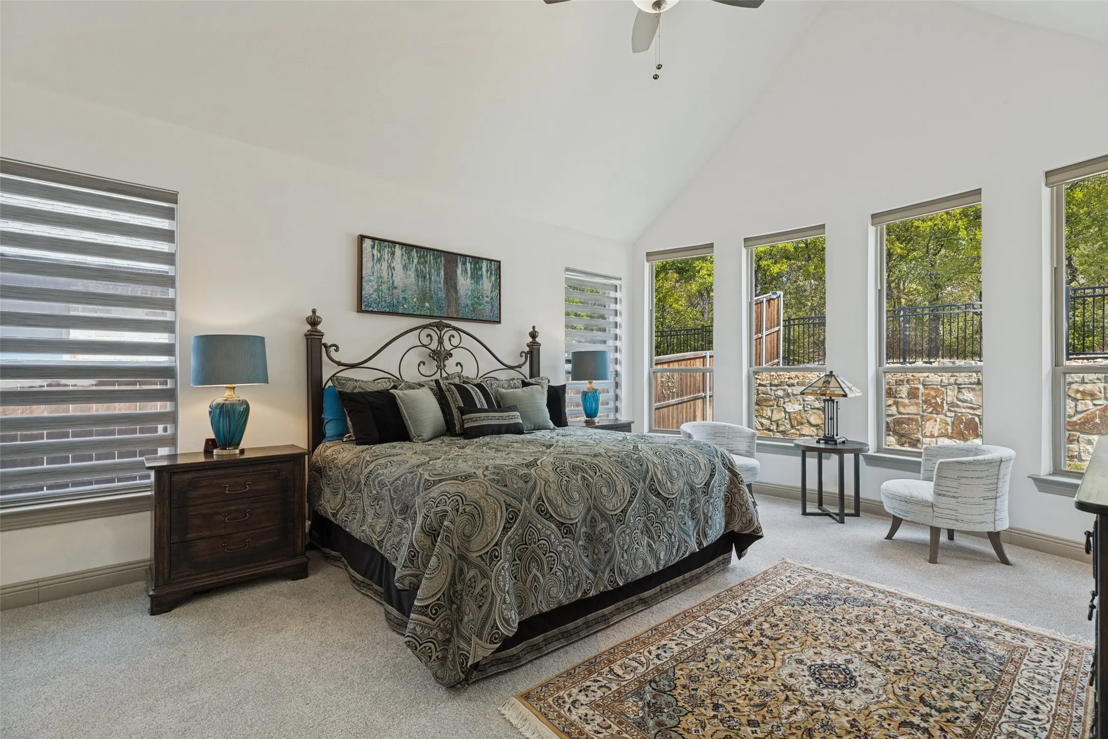 Luxurious master suite with vaulted ceiling and expansive windows overlooking the backyard paradise. Upgraded carpet