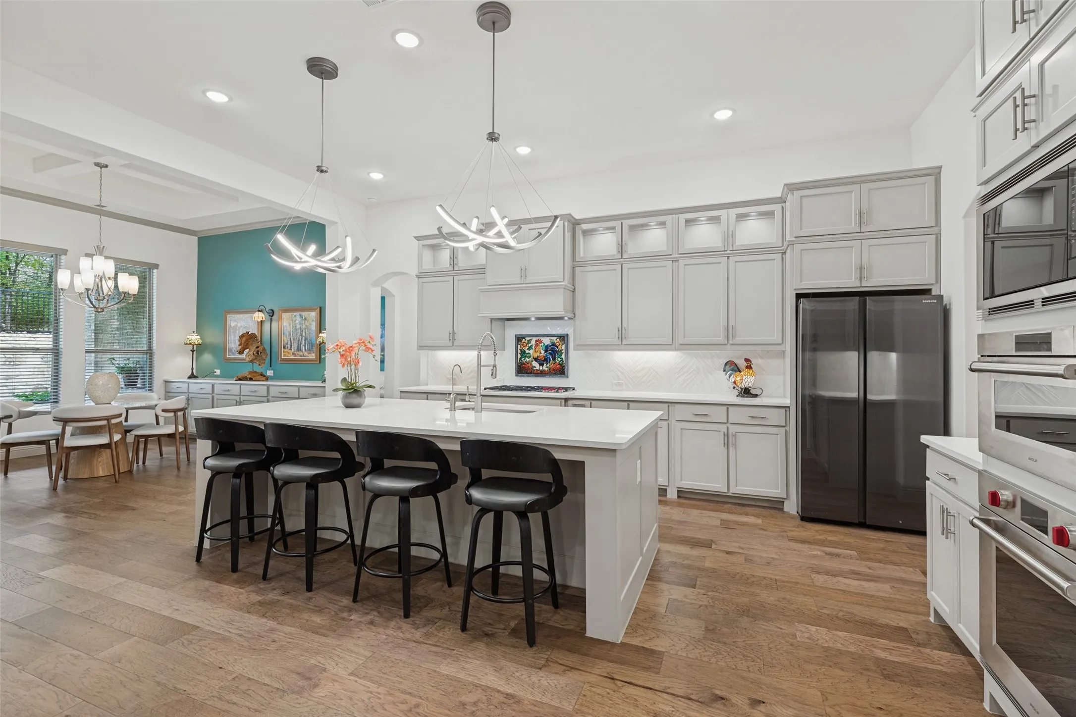 Another view showing the seamless flow from kitchen to dining area overlooking backyard.