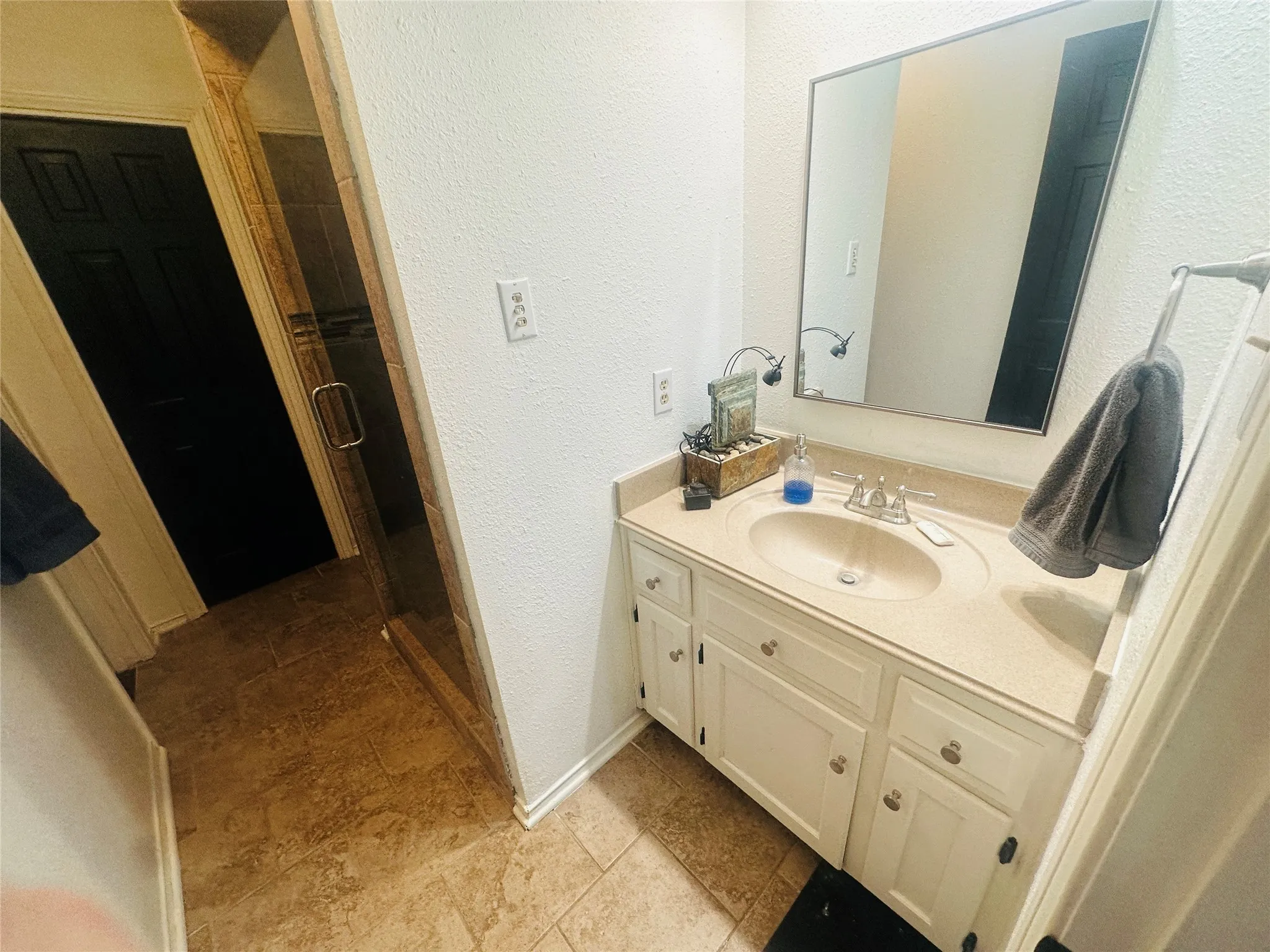 Cream-toned vanity with an integrated sink and base cabinetry, complemented by a framed mirror