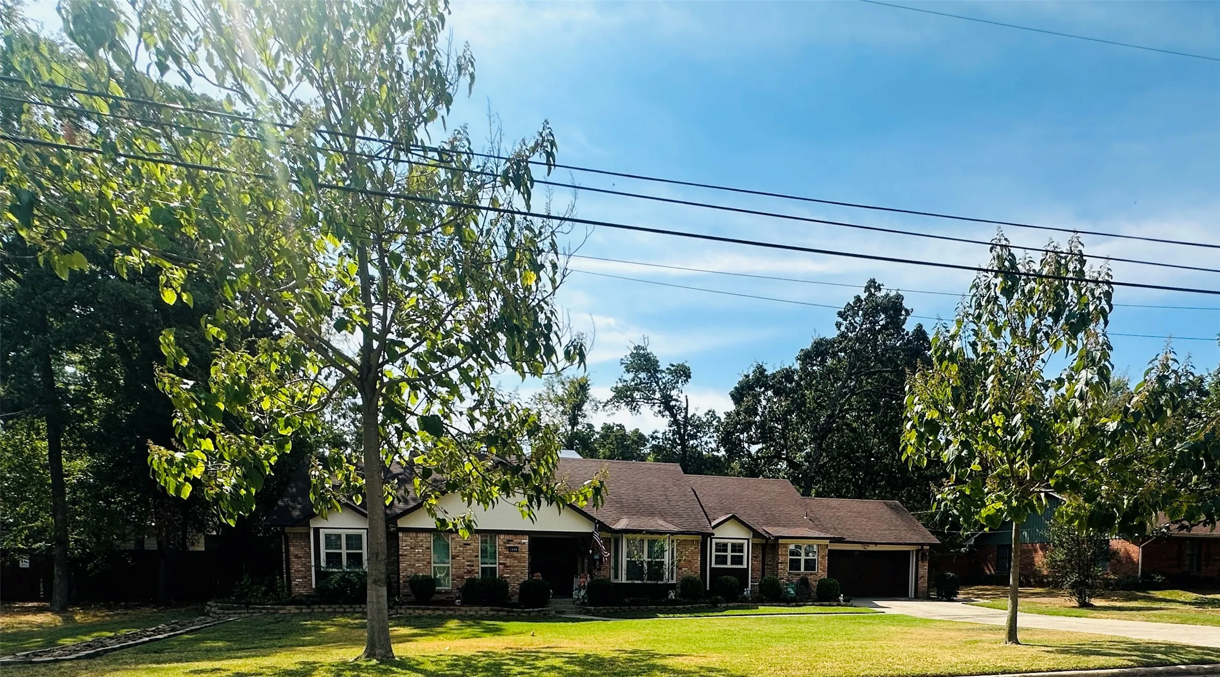 Single-story residence featuring a brick and siding exterior, an attached two-car garage, and a landscaped front yard