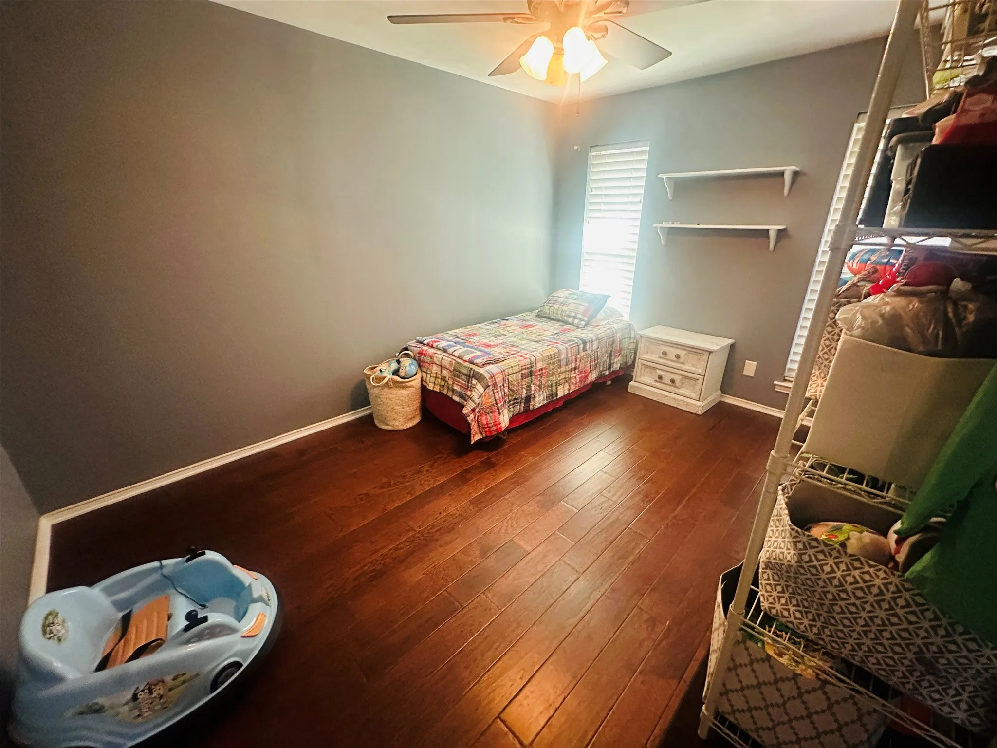 Wood-finish flooring throughout, complemented by a ceiling fan with integrated lighting