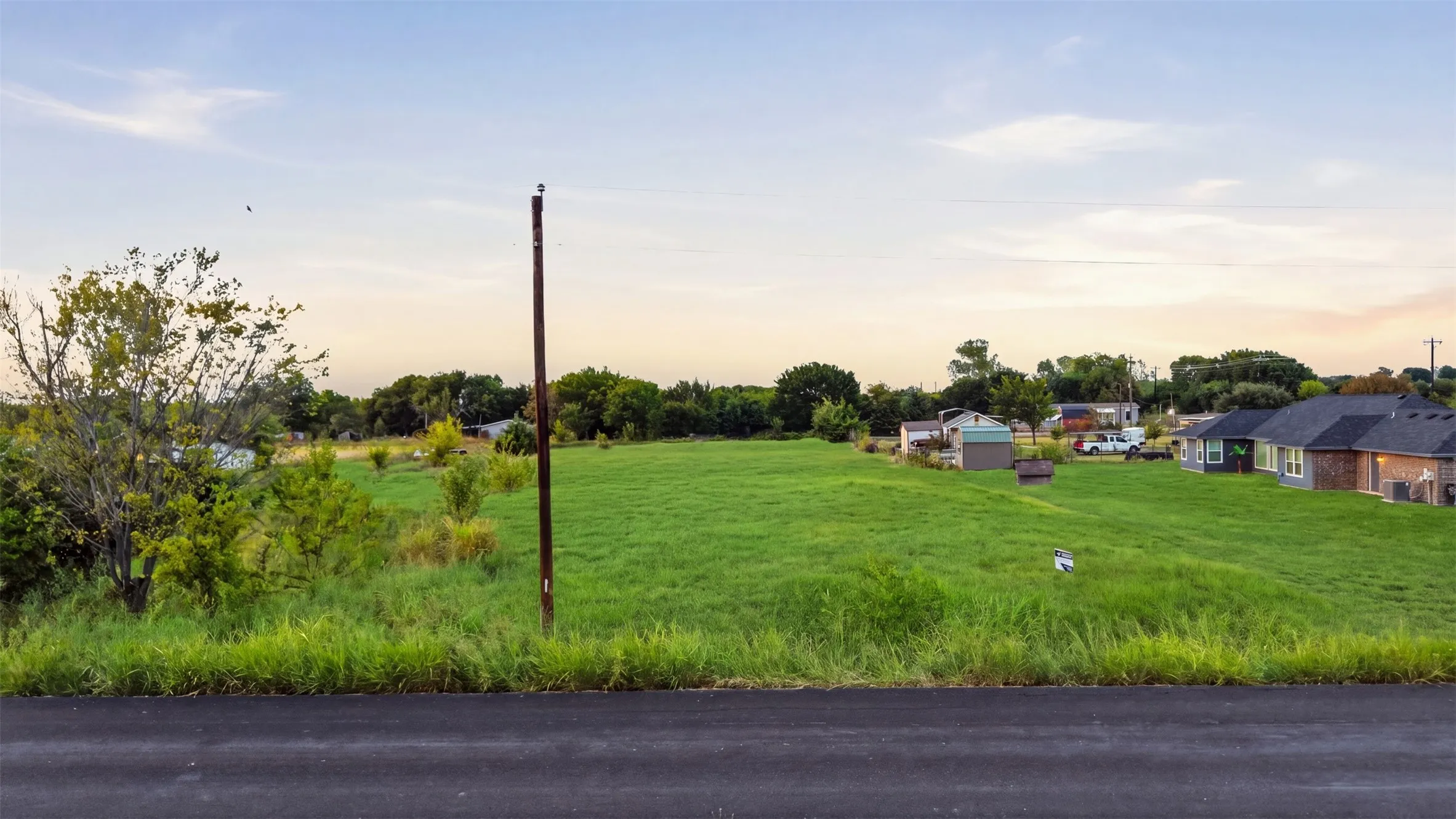 Expansive green field with natural ground cover, offering a spacious setting