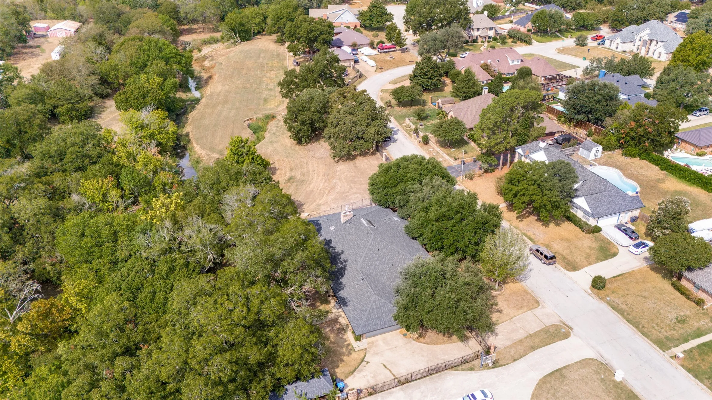 Aerial perspective showcasing the approximately .46-acre homesite, mature tree canopy and surrounding Lakewood neighborhood.