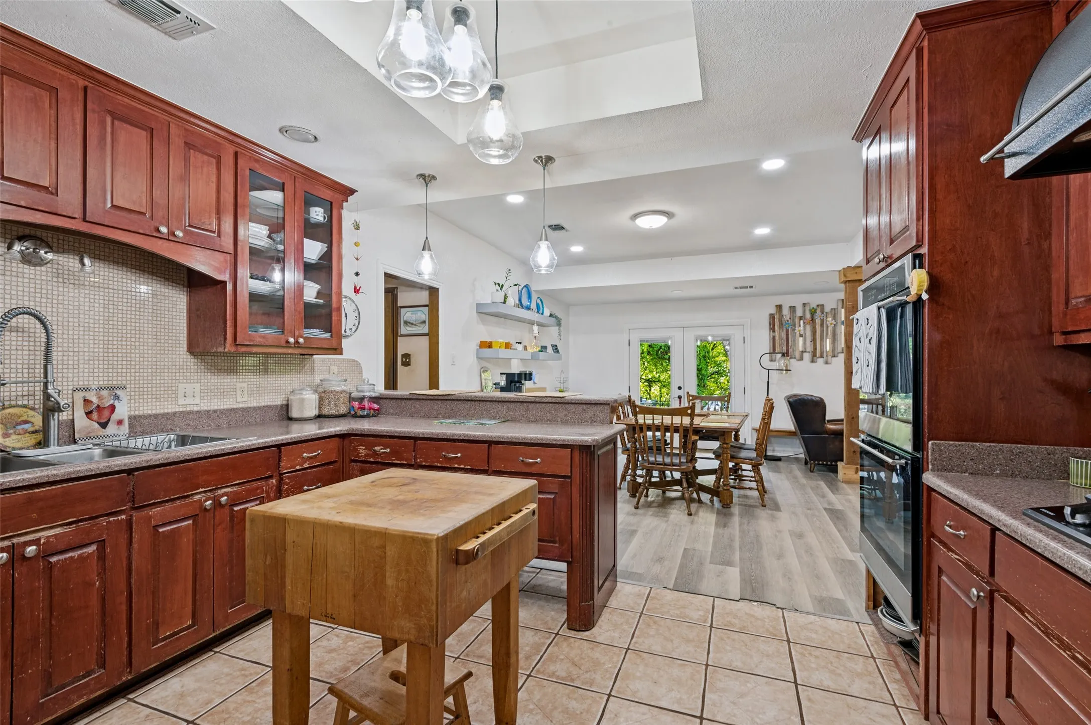 Kitchen featuring wood cabinetry, stone-finish countertops, and tile flooring