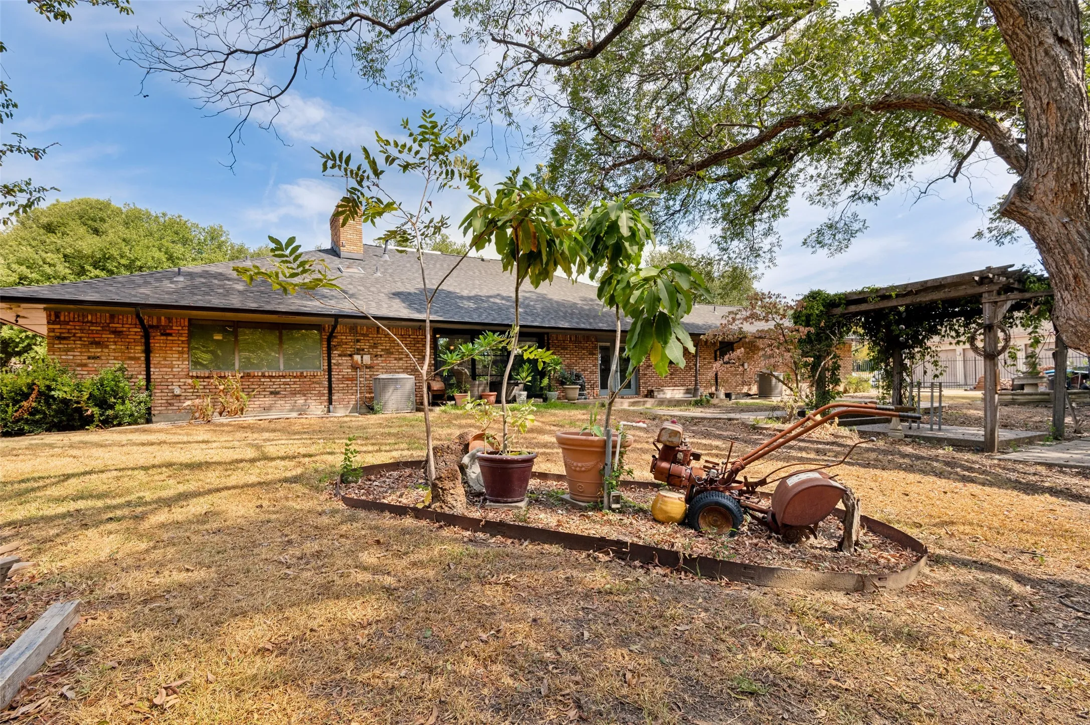 Rear exterior view showcasing the home's expansive single-story design, covered patio and backyard setting.