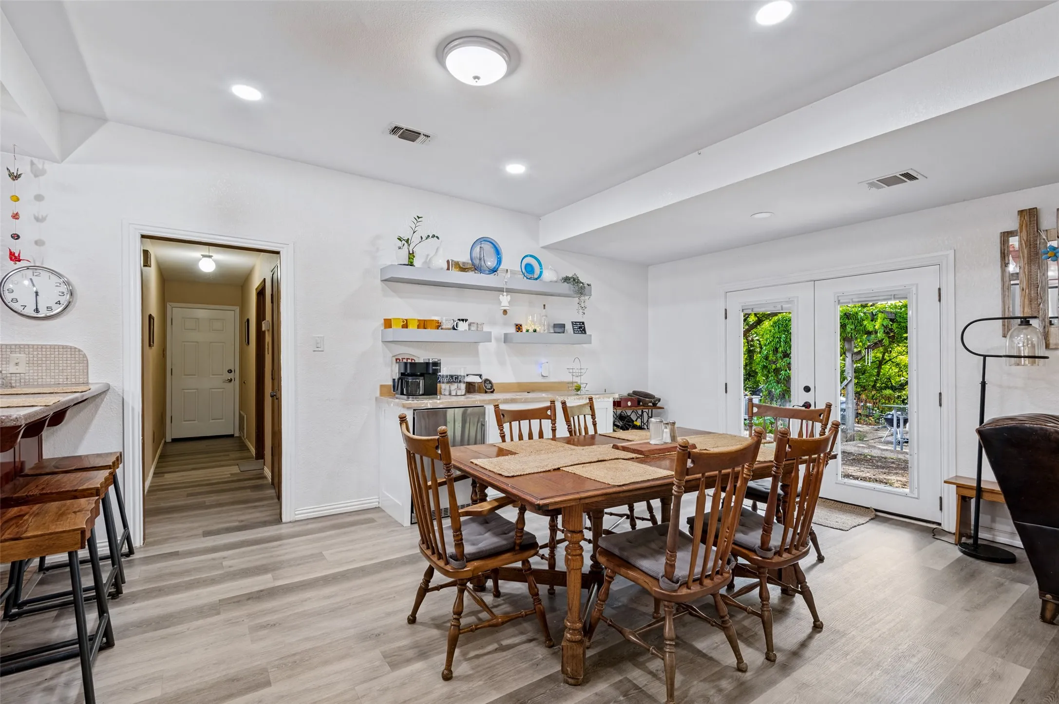 Breakfast area with French doors overlooking the backyard and a convenient beverage/coffee station with open shelving and counter space.