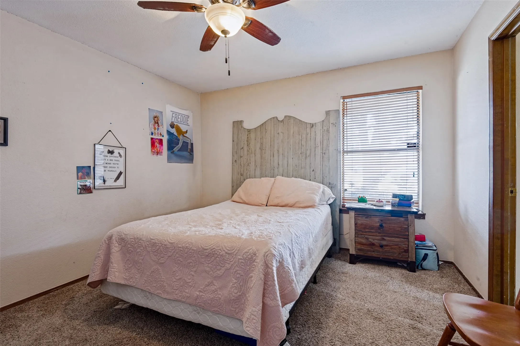 Secondary bedroom featuring carpeted flooring, natural light, window coverings and a ceiling fan with light.