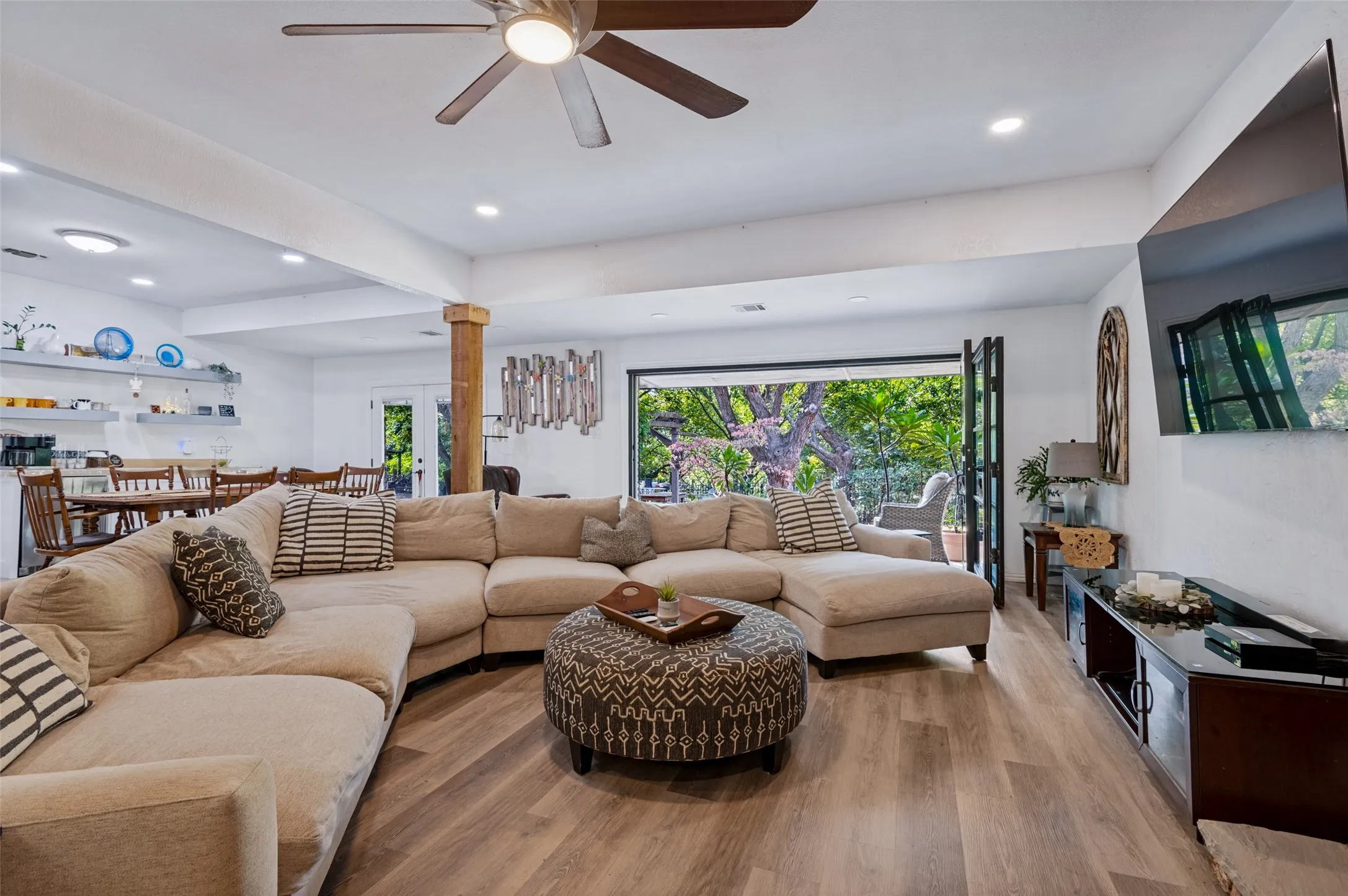 Spacious great room with generous seating space and open views to the breakfast area, while the wall of glass doors brings the outdoors into the living space.