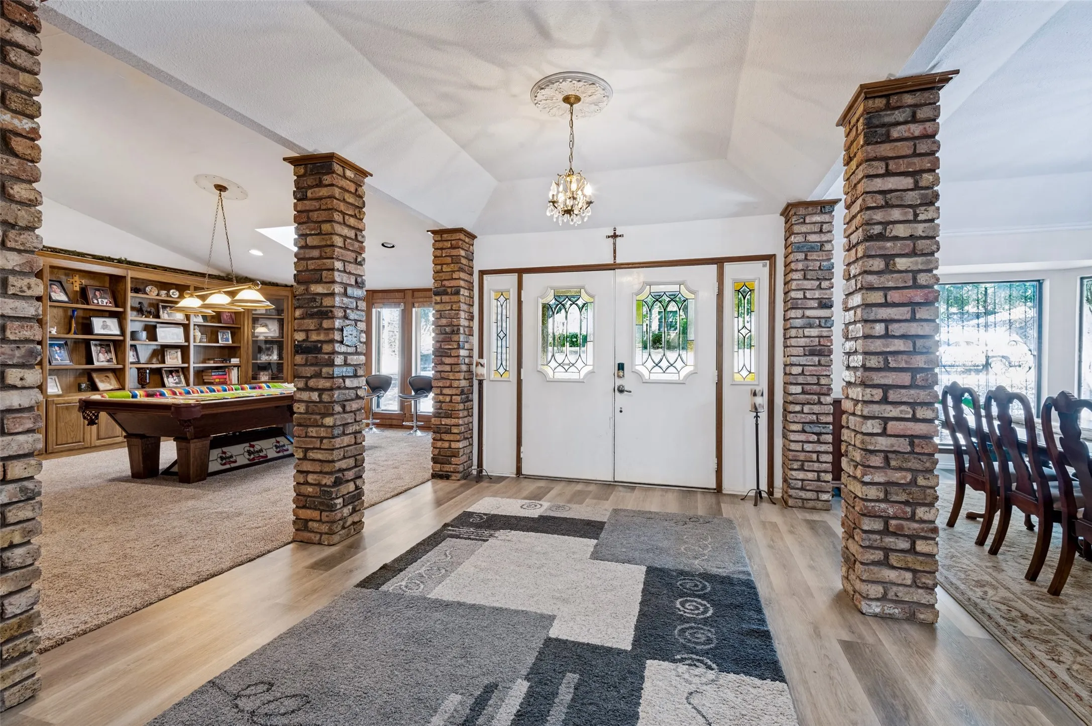 Spacious entry featuring distinctive brick columns, decorative glass double doors and an open flow to the adjoining living and dining spaces.