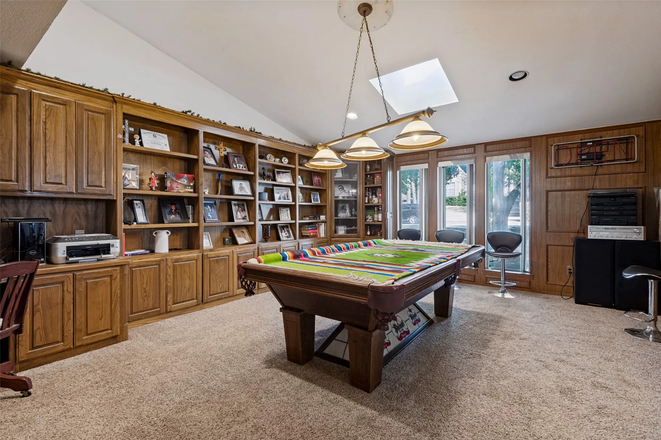 Second living area featuring extensive built-in cabinetry and shelving, a skylight and generous space for recreation, entertaining or relaxation.