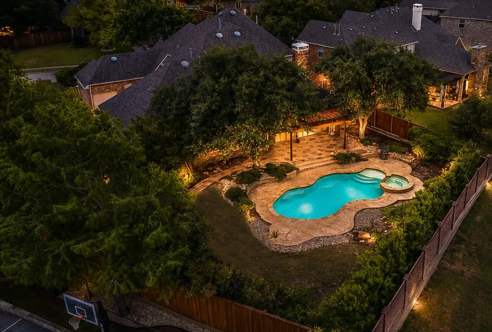 Expansive backyard featuring a freeform pool, integrated spa, and a flagstone patio