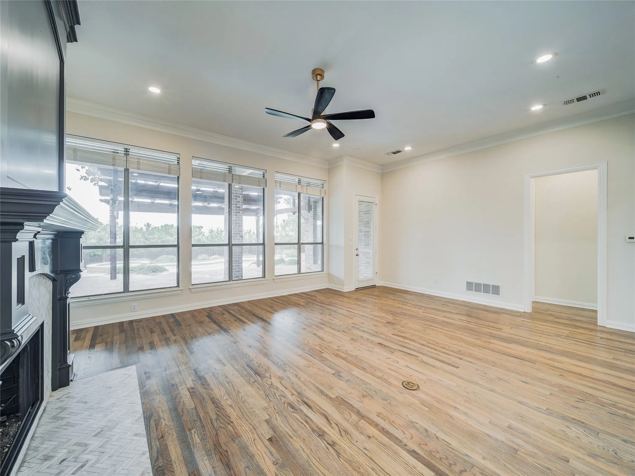Hardwood flooring, recessed lighting, ceiling fan, fireplace, and extensive window treatments