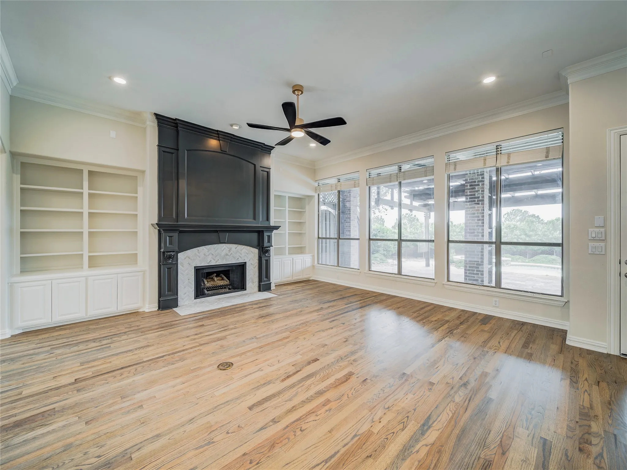 Spacious room with wood-finish flooring, a ceiling fan, and recessed lighting