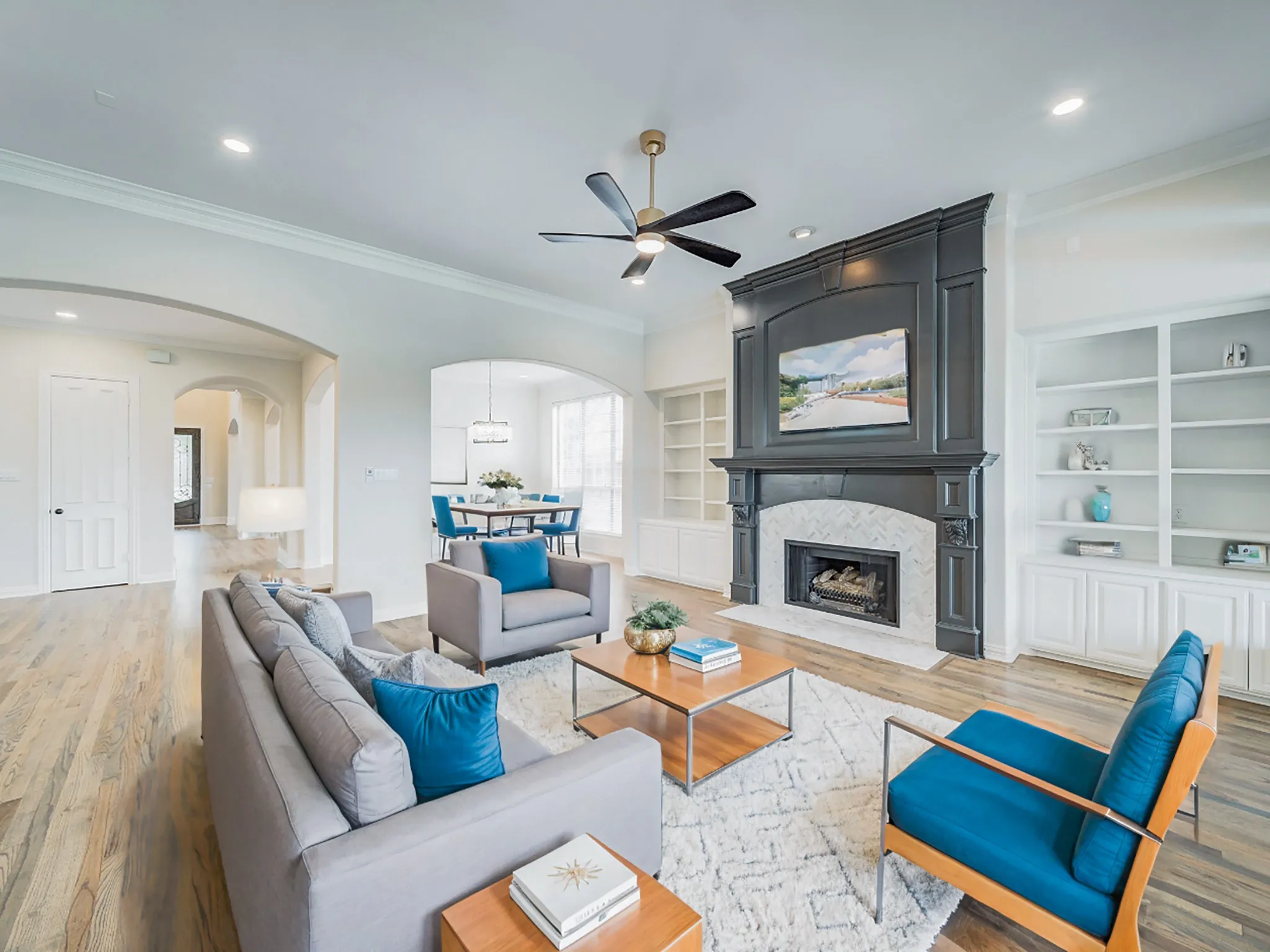 Living area featuring wood-finish flooring, recessed lighting, and a dark-toned fireplace with a light-tiled surround