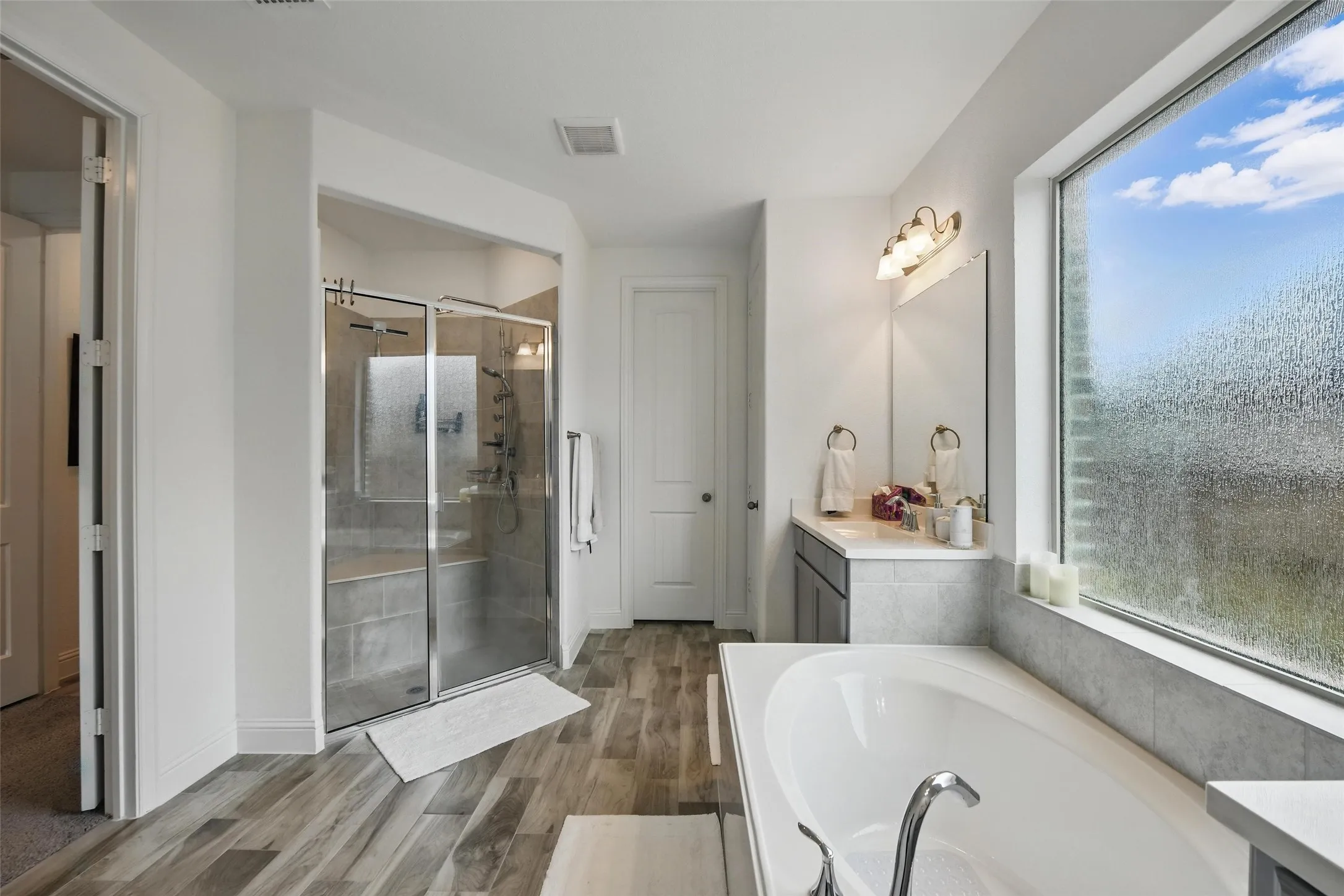 With garden tub, walk-in shower, and separate vanities.