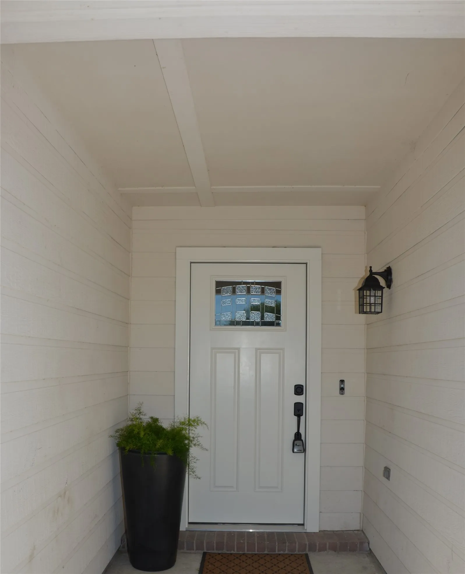 Recessed entry with panel siding and a painted ceiling