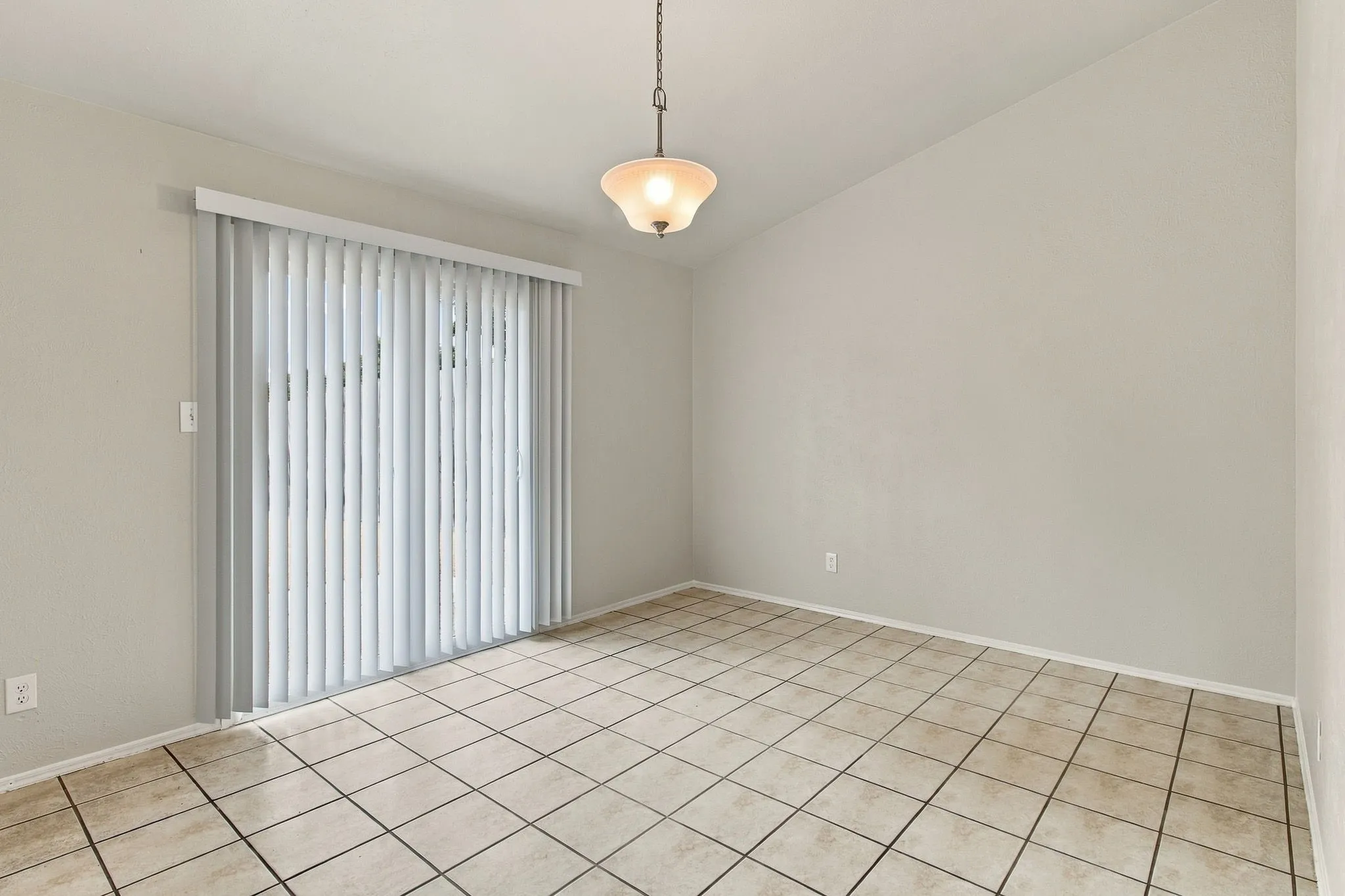 Tile flooring, neutral wall tones, and a suspended ceiling light fixture