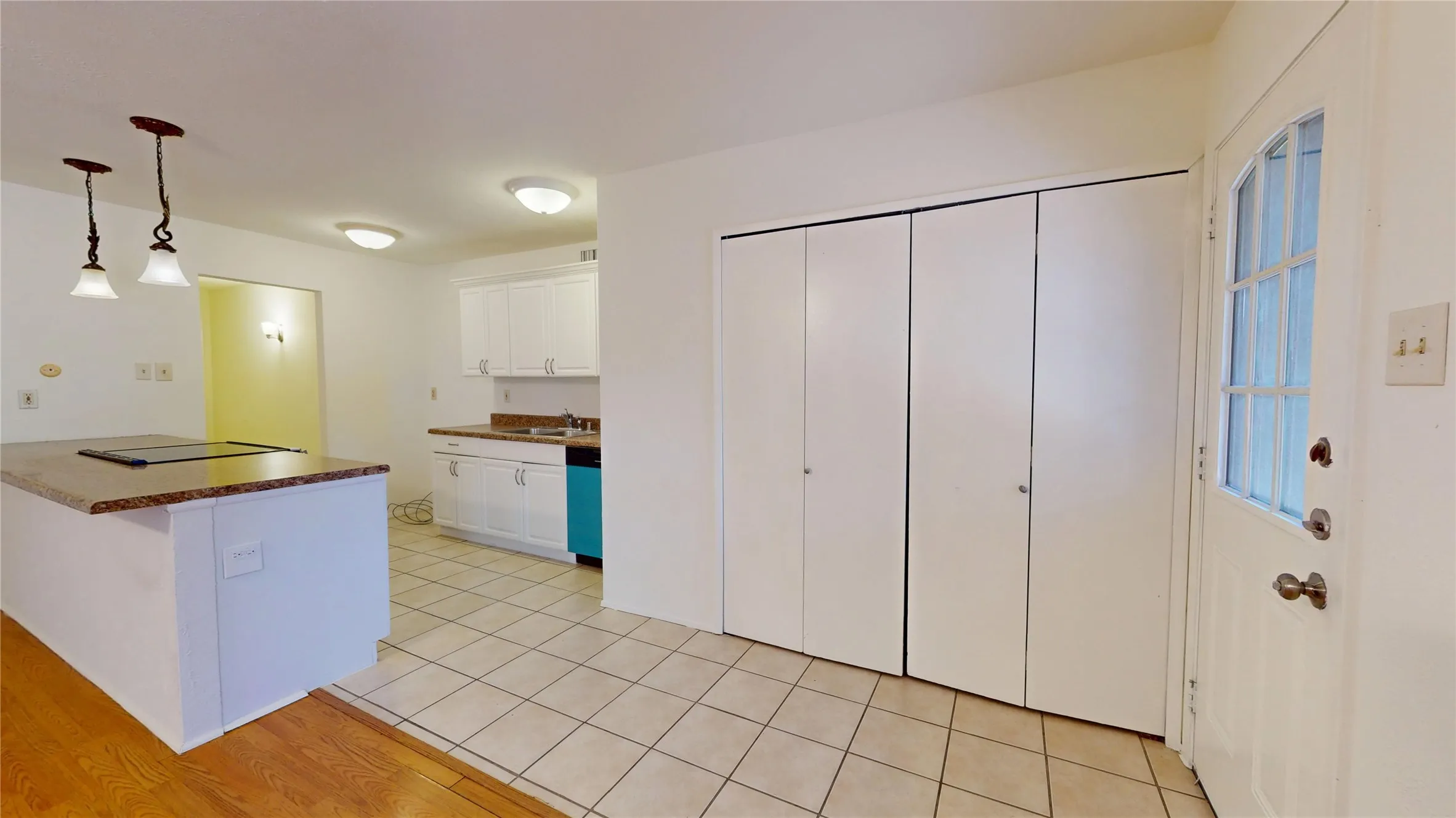 Kitchen featuring white cabinetry, a built-in electric cooktop on an island with pendant lighting, and tile flooring