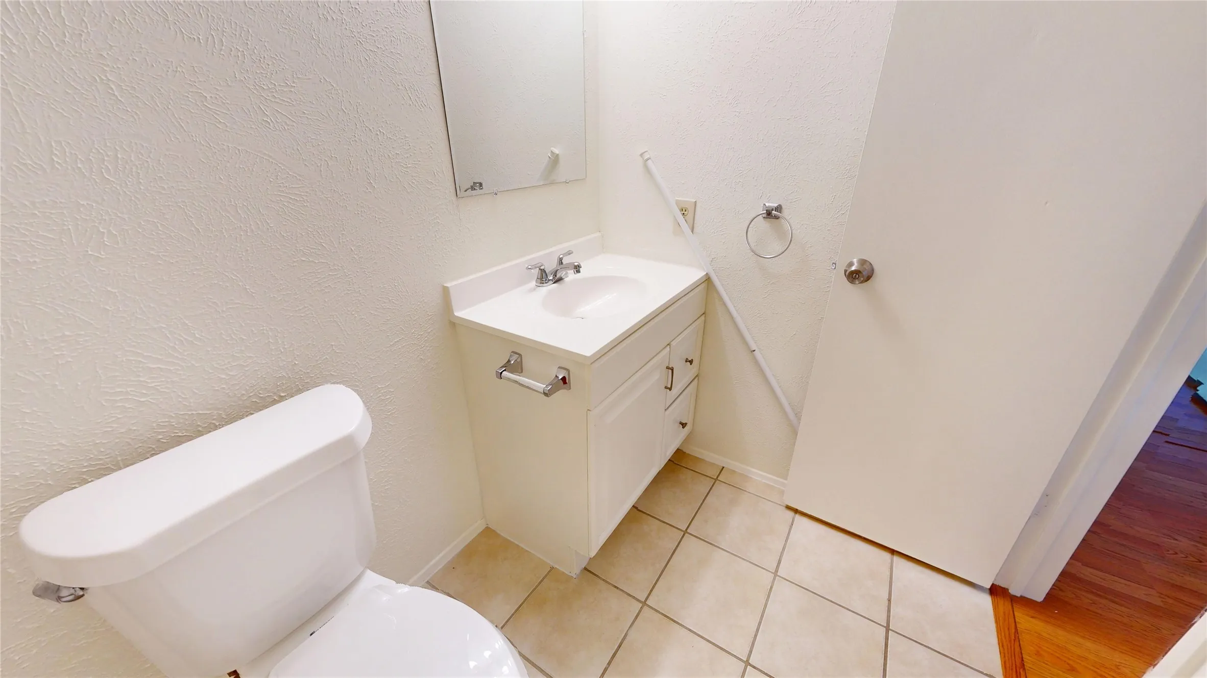 White vanity with integrated sink, chrome faucet, and storage cabinetry