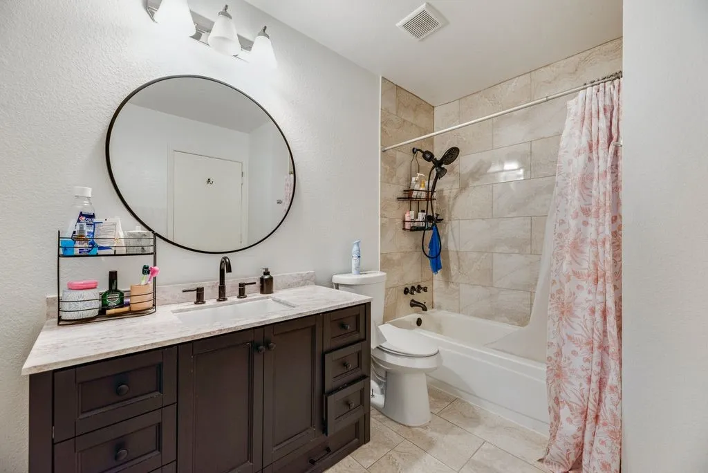 Dark wood-finish vanity with a light-toned countertop, complete with a single basin sink and dark-toned faucet