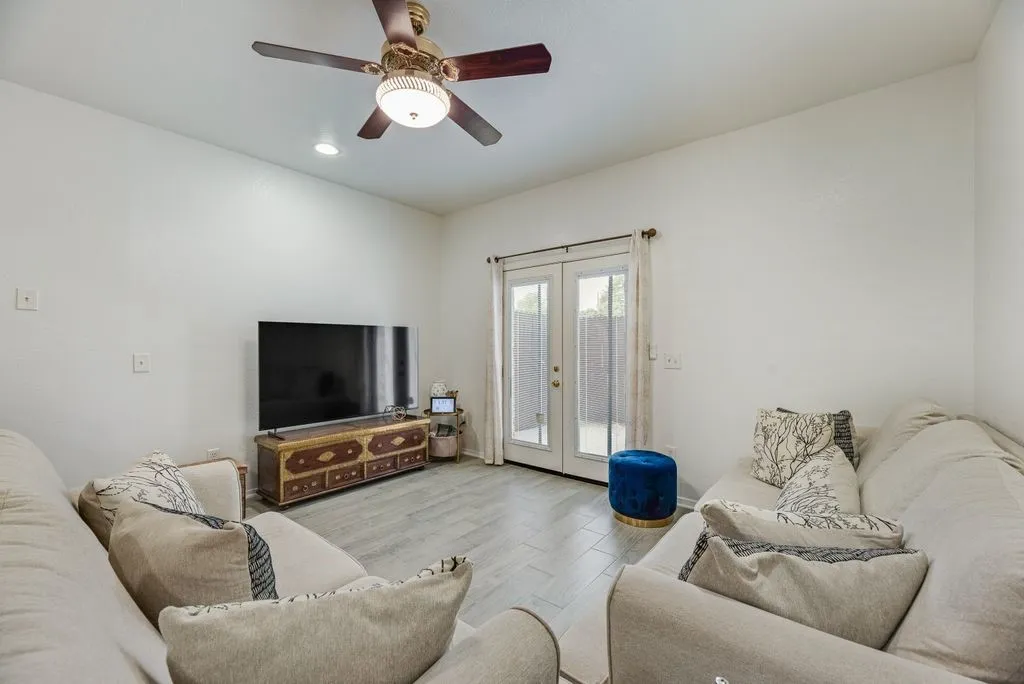 Recessed lighting, ceiling fan with integrated light fixture, wood-finish flooring, and double French doors with transom windows