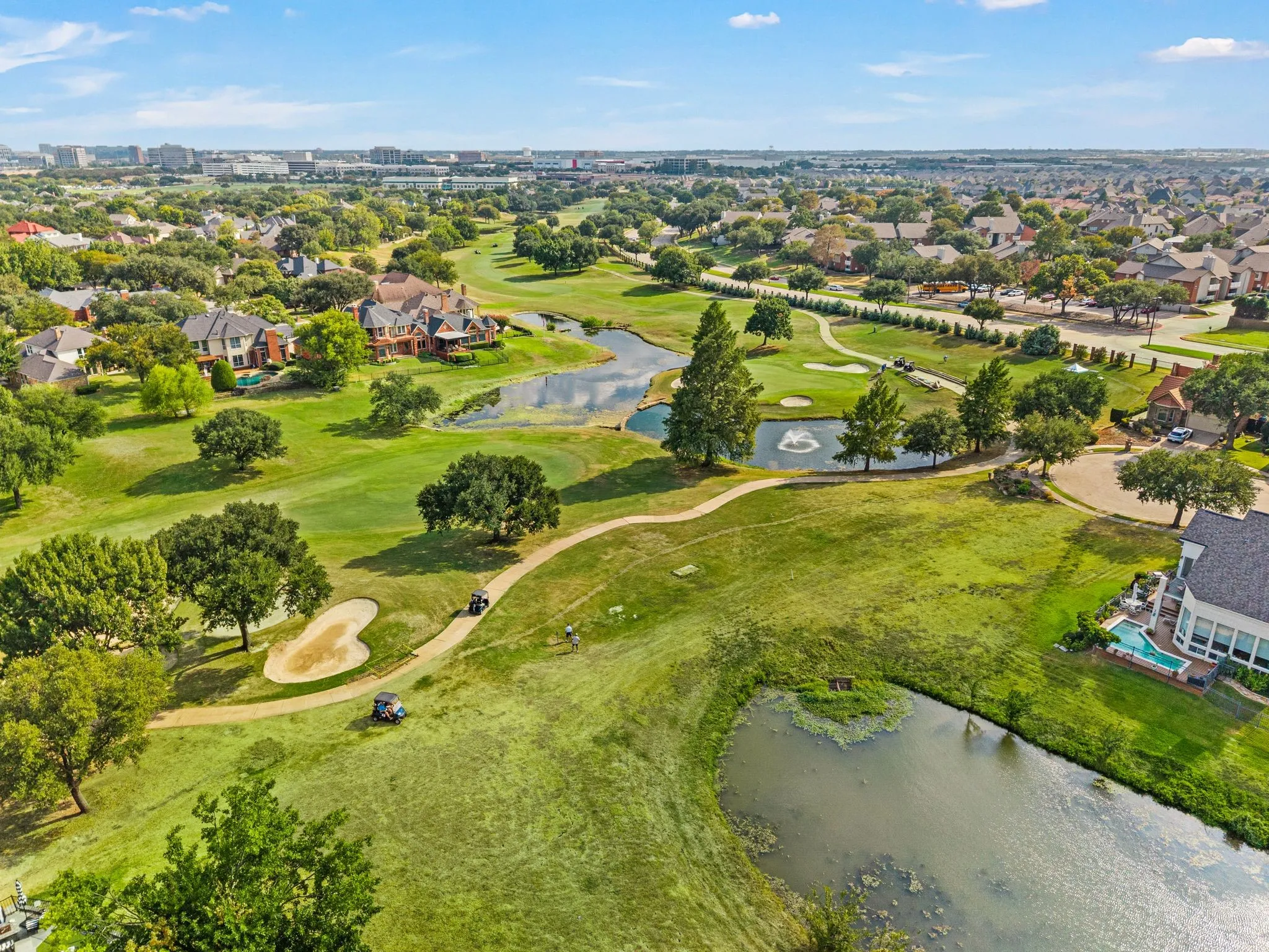 Expansive golf course property featuring multiple water features, mature trees, and manicured greens