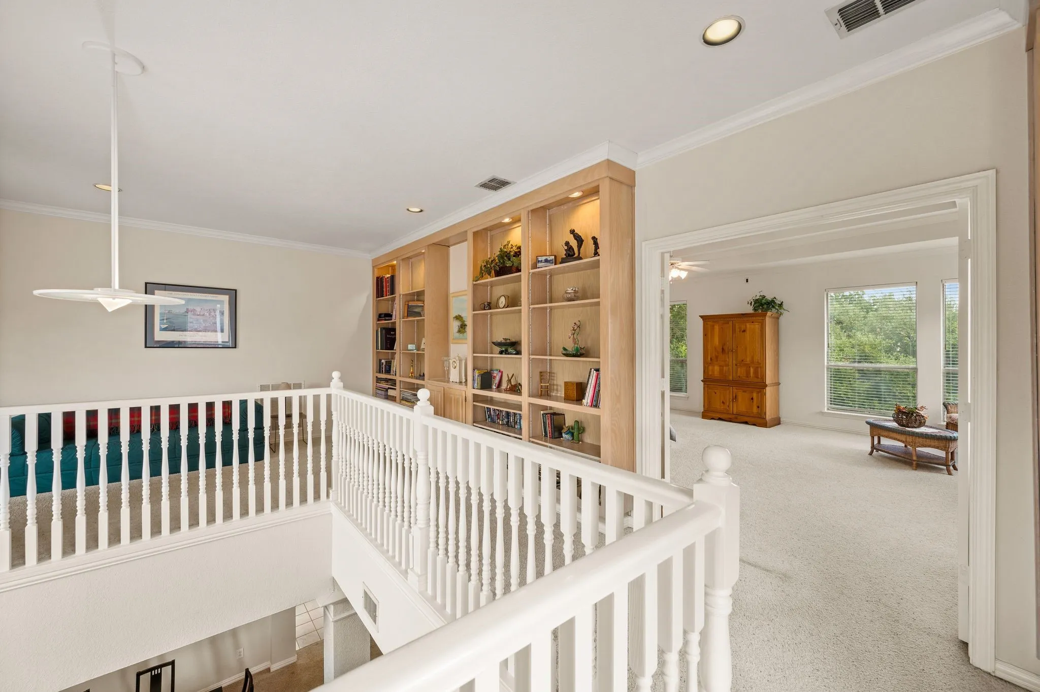 Built-in shelving with integrated lighting, recessed ceiling lighting, and a ceiling fan