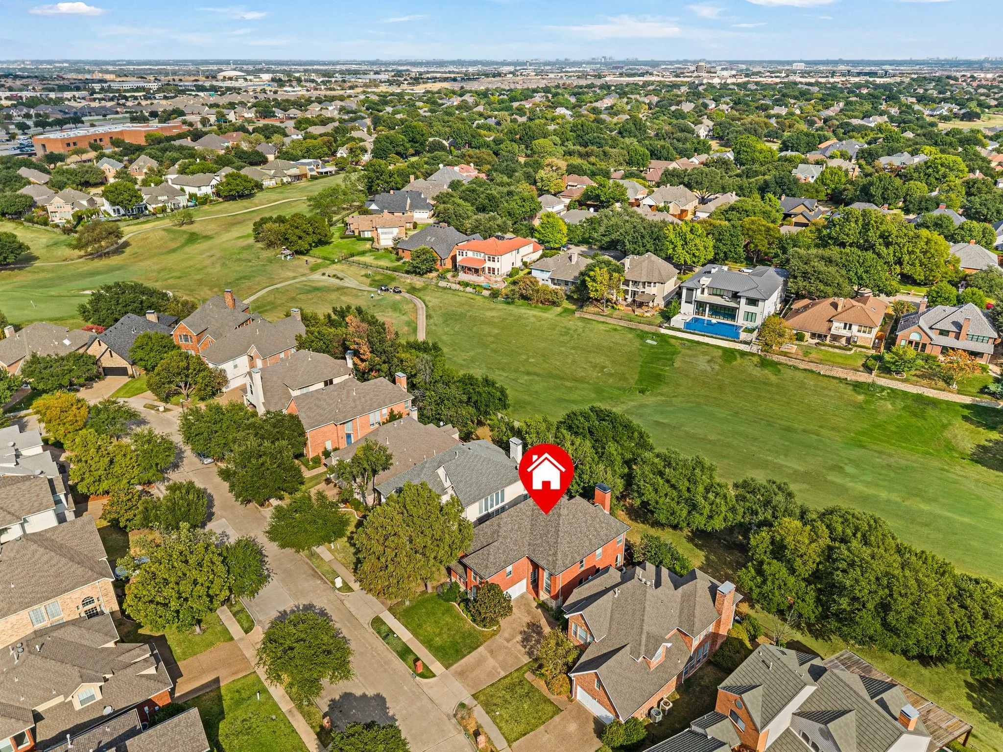 Residential property with a gabled roof and brick exterior, situated on a tree-lined street with mature landscaping