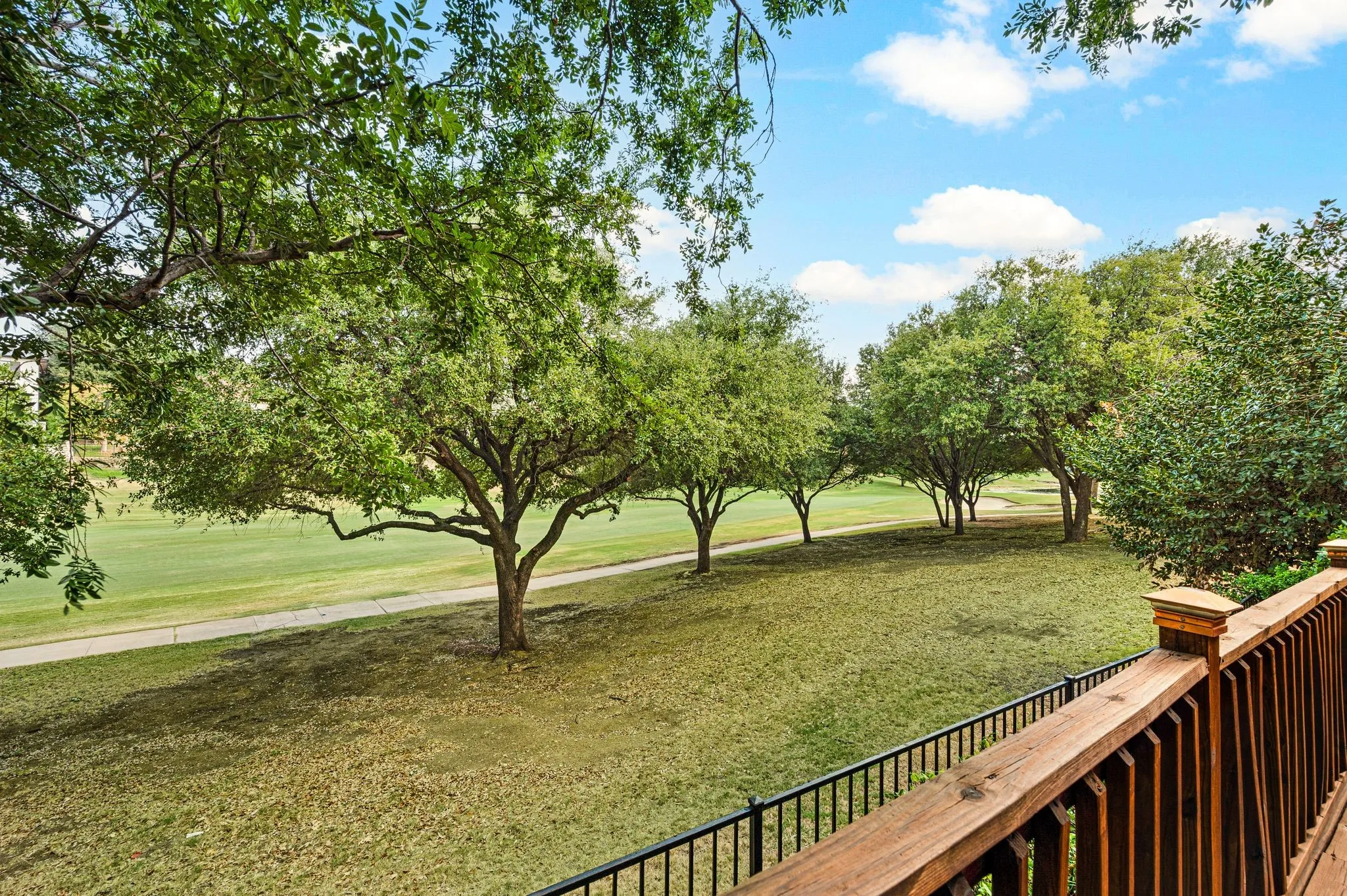 Expansive green space featuring mature trees and a manicured lawn