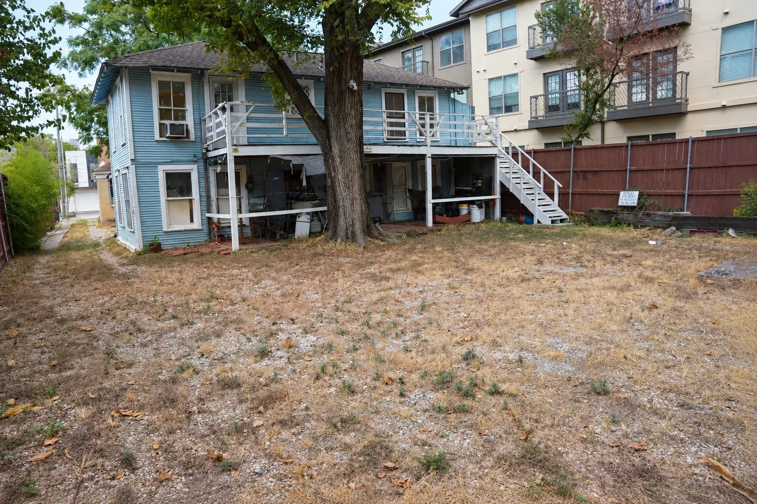 Rear elevation showing exterior access stairs and yard depth.