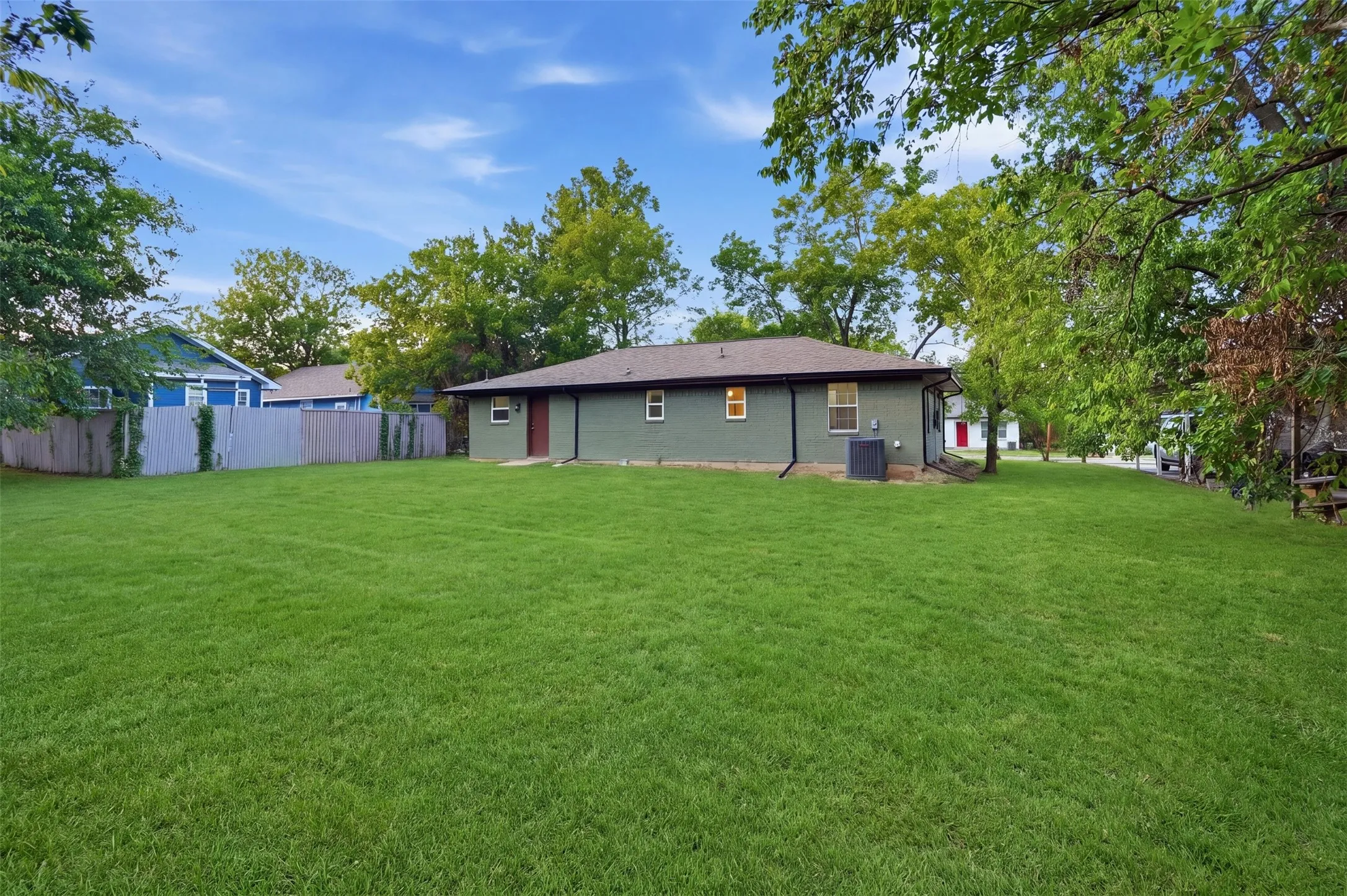 Expansive grassy yard with a privacy fence