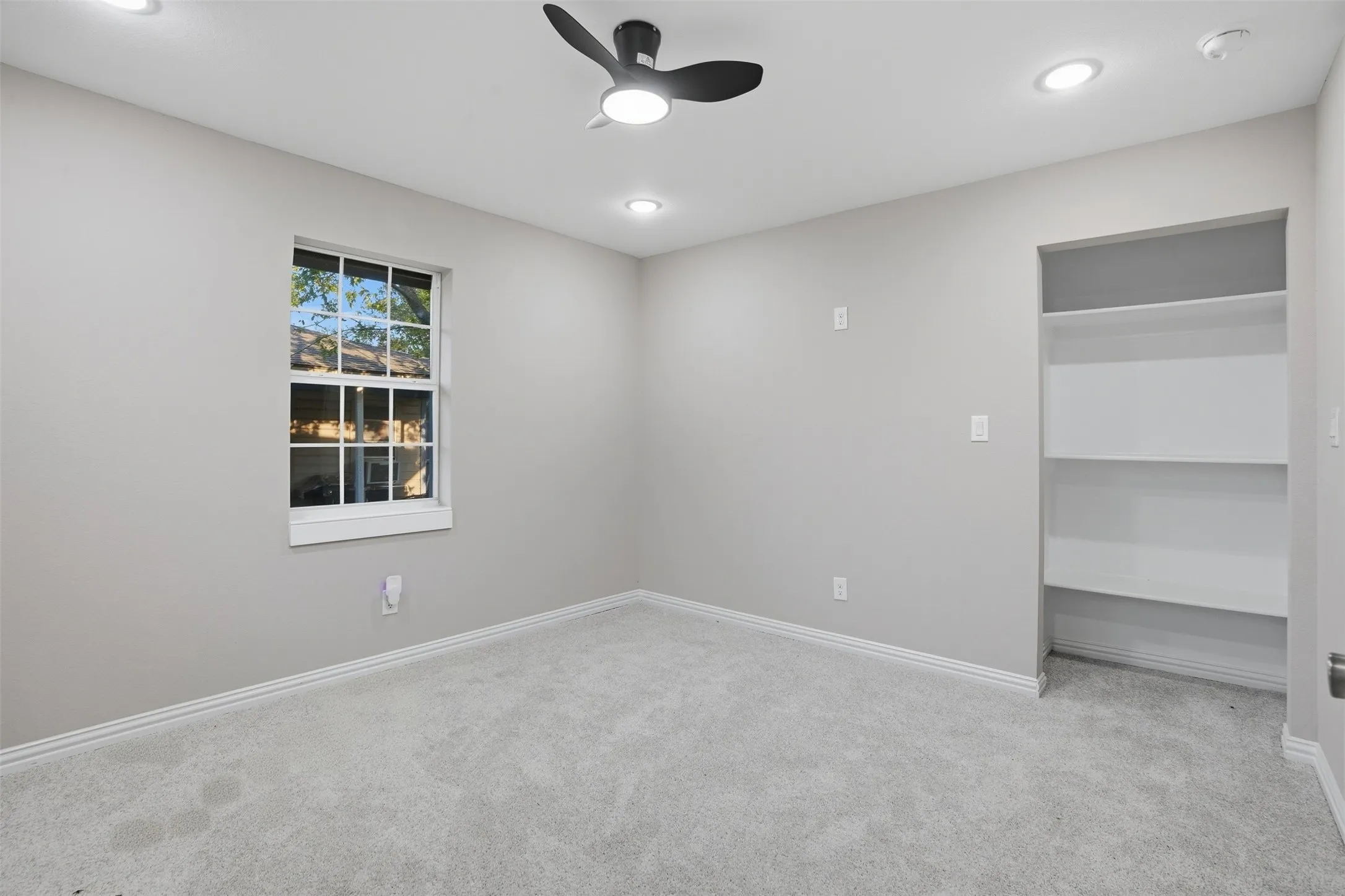 Recessed lighting, ceiling fan, built-in shelving, window, and carpeted flooring