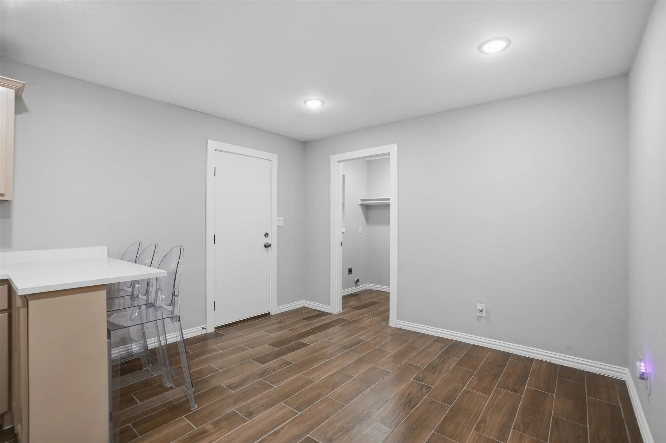 Wood-finish flooring, recessed lighting, and light-toned walls