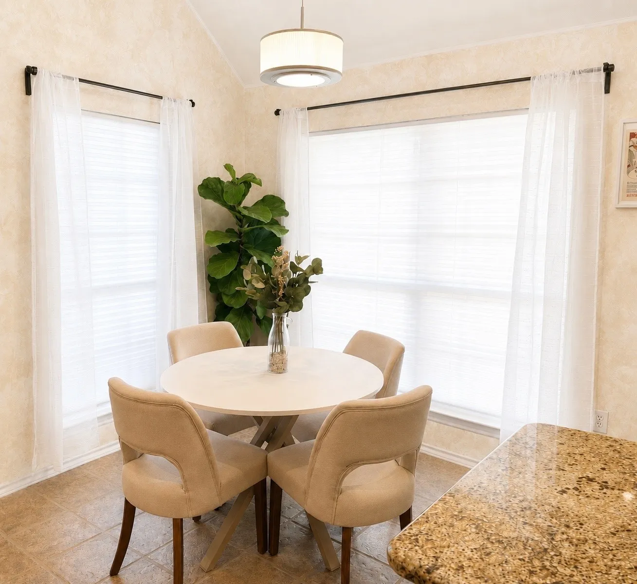 Breakfast nook featuring extensive natural light from multiple windows, an overhead semi-flush drum light fixture, and tile flooring