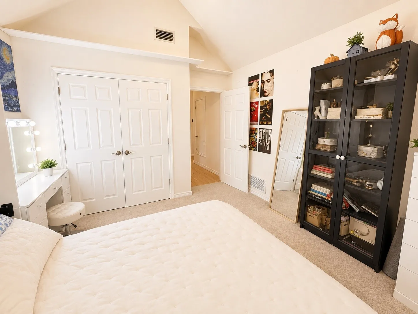 Vaulted ceiling with an air vent, two-panel interior doors, and carpet flooring
