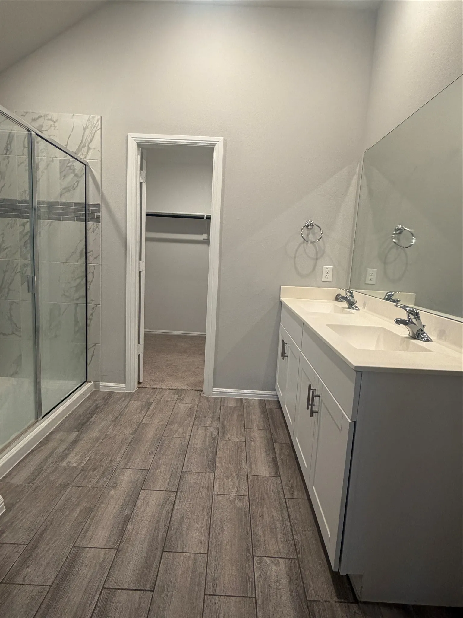 Dual vanity with undermount sinks, white cabinetry, and a large mirror