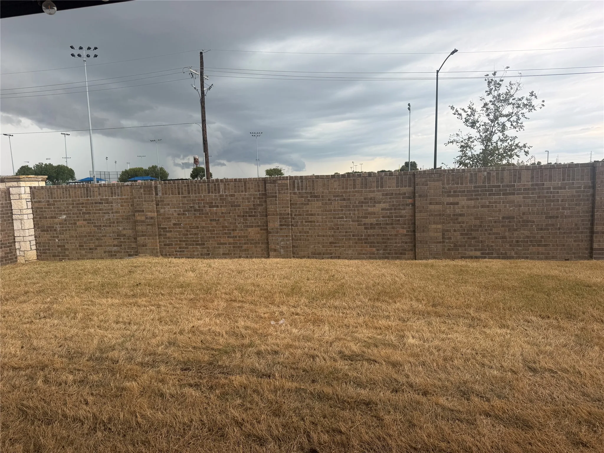 Brick privacy wall with stone pillar accent