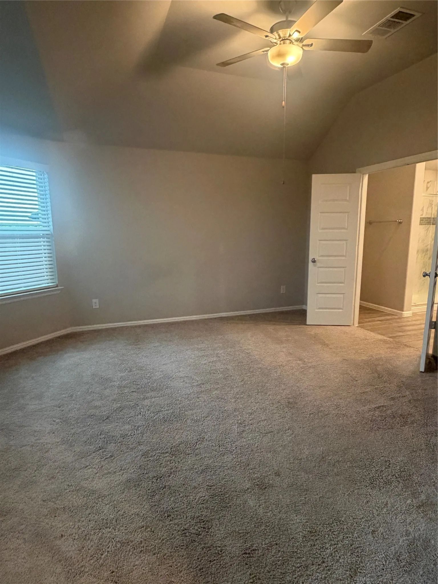Vaulted ceiling with an attached ceiling fan and light fixture